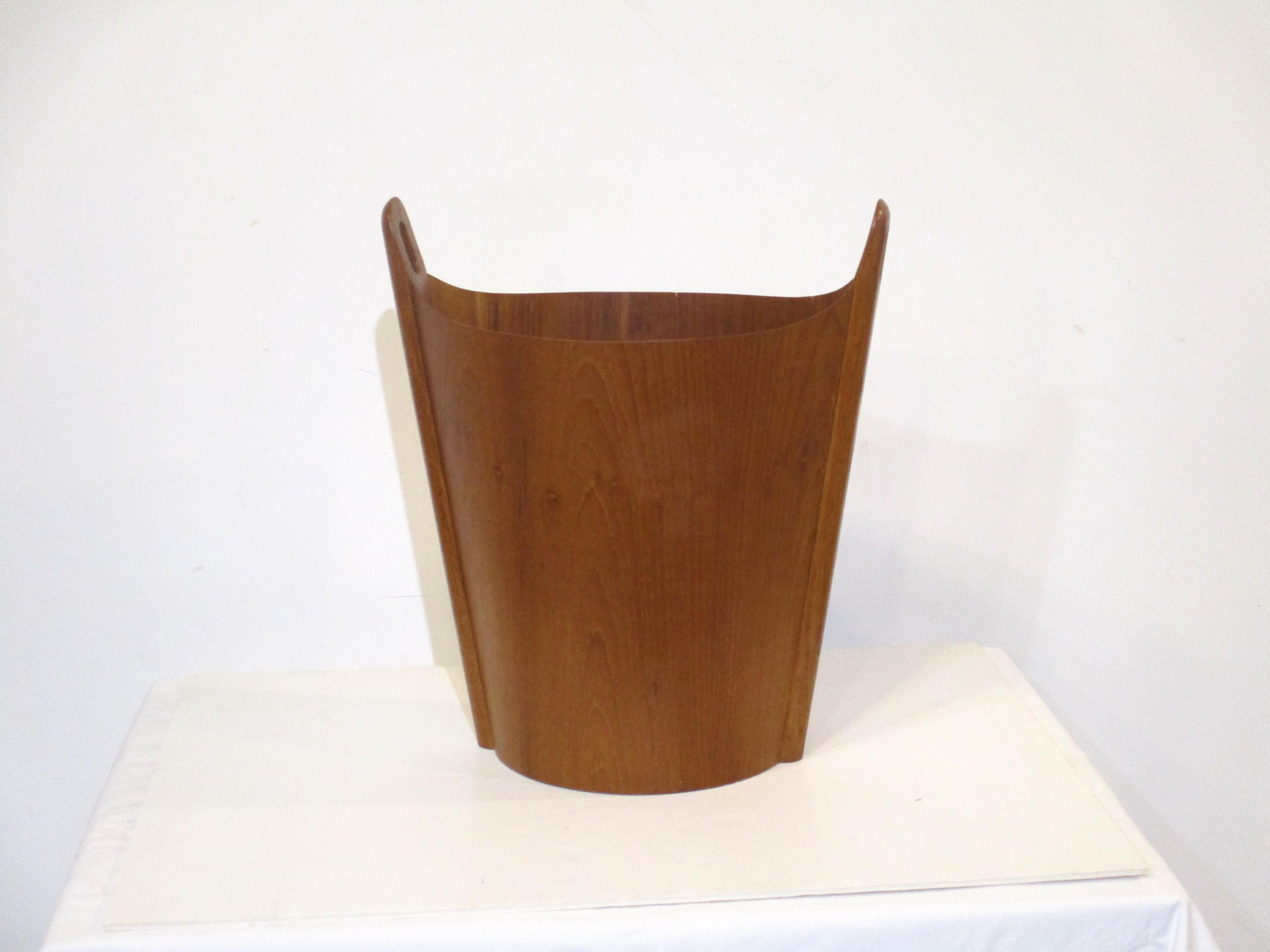 A very well crafted teak wood waste or magazine basket with handles to each side. A simple but complex form with the bent wood curved and integrated into the handles, designed by Einar Barnes for P.S. Heggen made in Norway. Retains the original