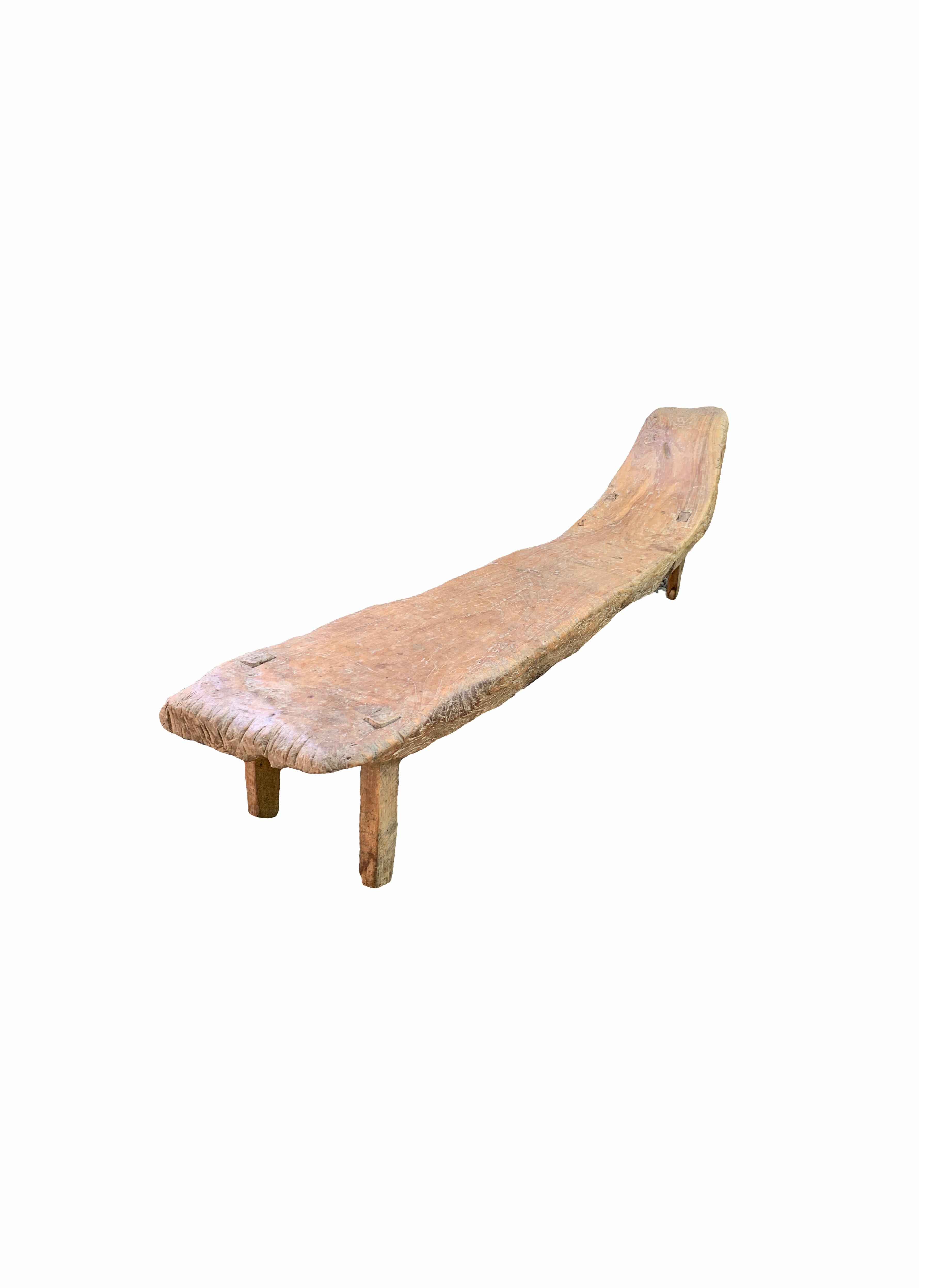 This hand-crafted teak wood low bench originates from the Island of Madura, off the coast of Northeastern Java. Its irregular organic shape contributes to its appeal. This bench dates to the Mid-20th century. 

Dimensions: height to seat 26 cm,