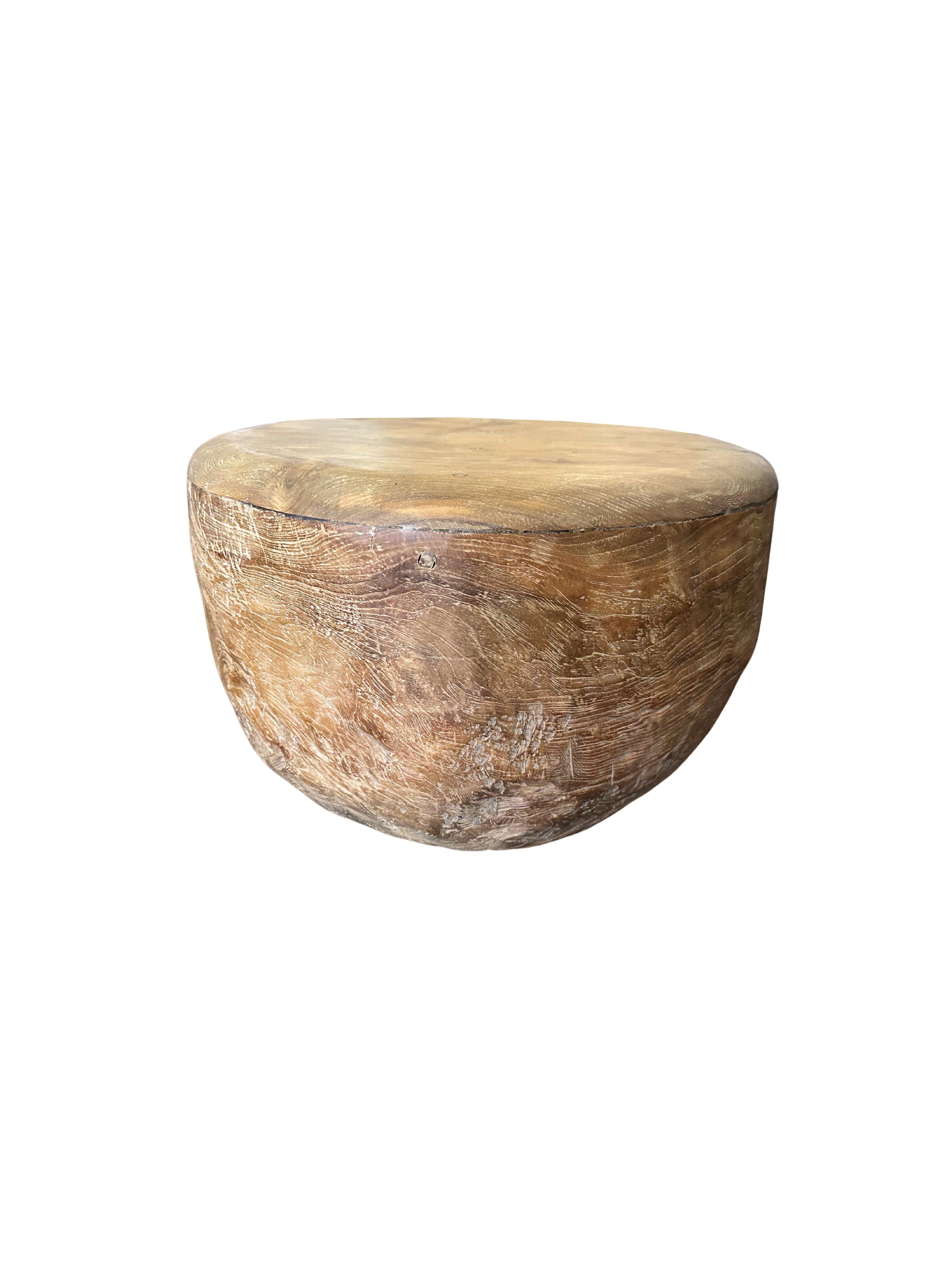 This teak burl side table was crafted on the island of Java, Indonesia. It comprises of a solid teak burl base and thin, round, sanded down table top. It features a robust structure with beautiful wood patterning. Perfect to be used as a coffee