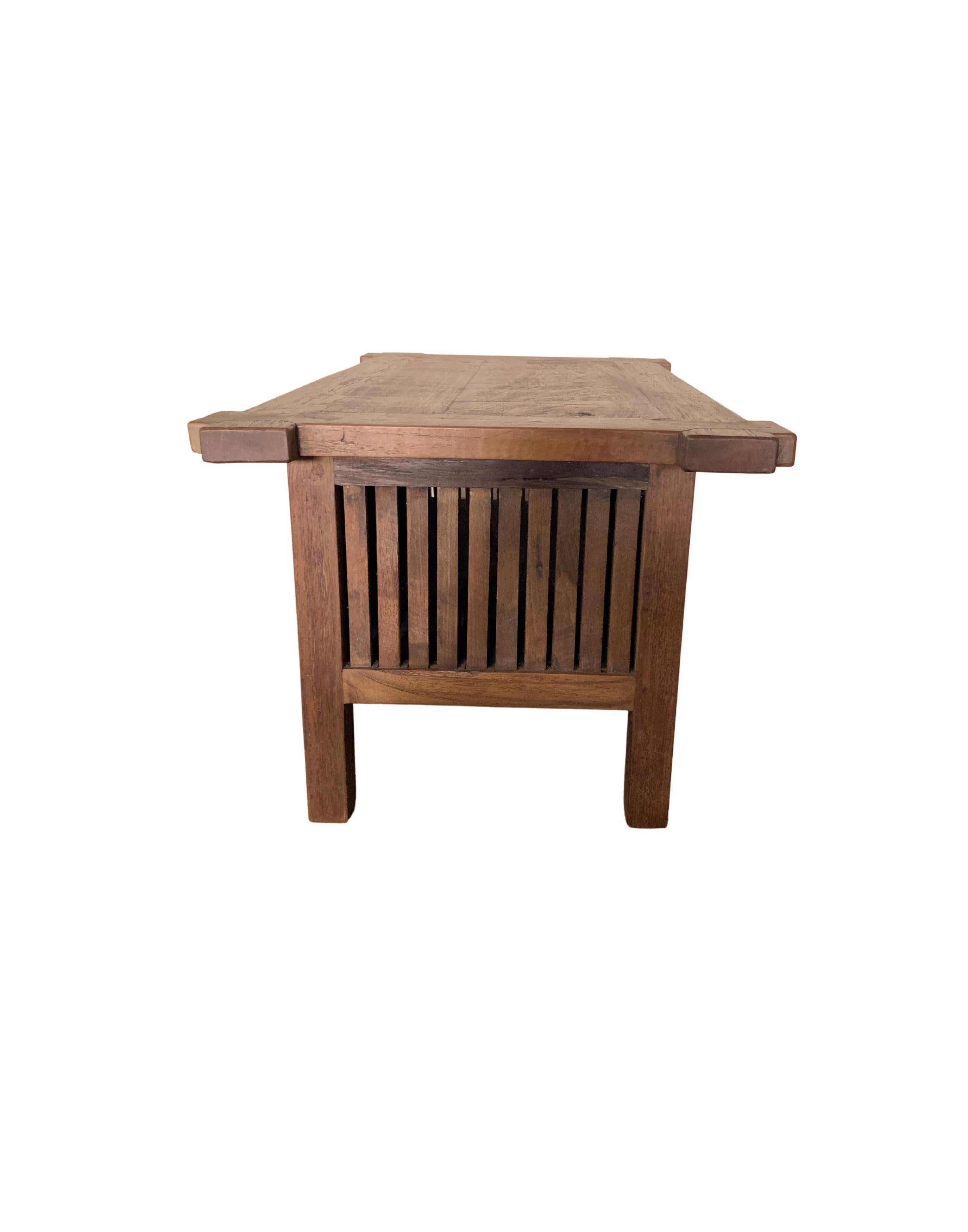 A teak wood cabinet with two elegant doors that open up to a generous storage space. Two ringed iron handles are featured on the doors. The slits on its sides add to its charm. The mix of wood textures and shades will help to bring warmth to any