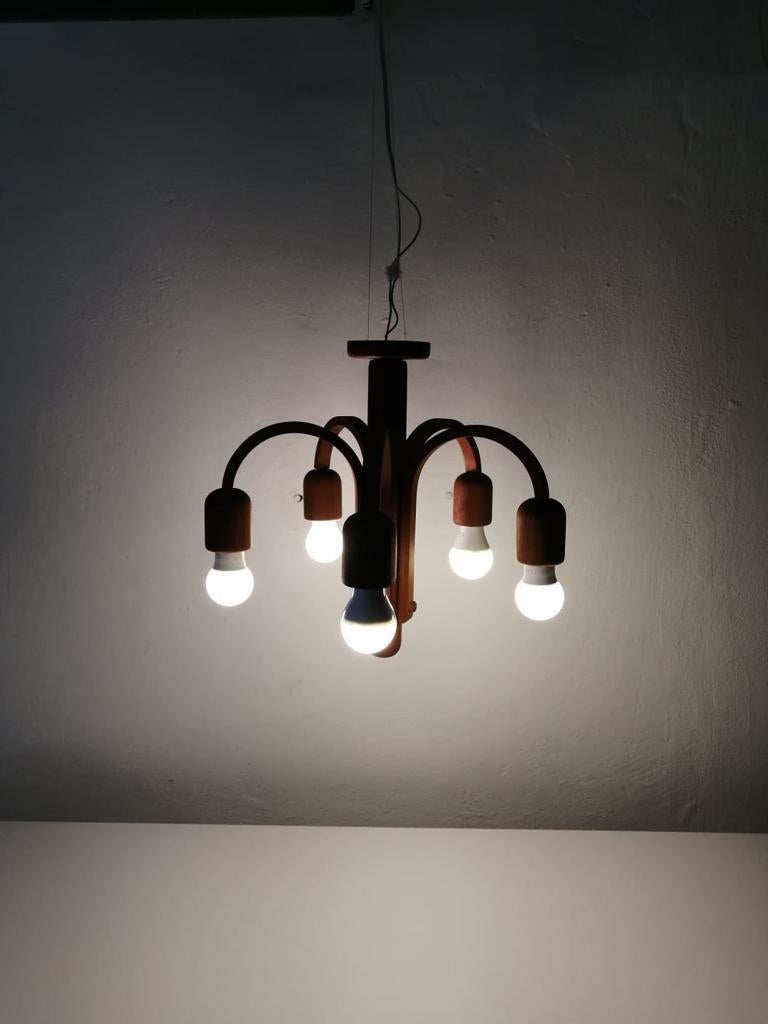 Teak wood 5 armed ceiling lamp by Domus, 1970s Italy 

Made of full teak wood chandelier
Lamp is in good condition. No damage, no crack
This lamp works with 5 x E14 light bulbs.
Wired and suitable to use with 220V and 110V for all