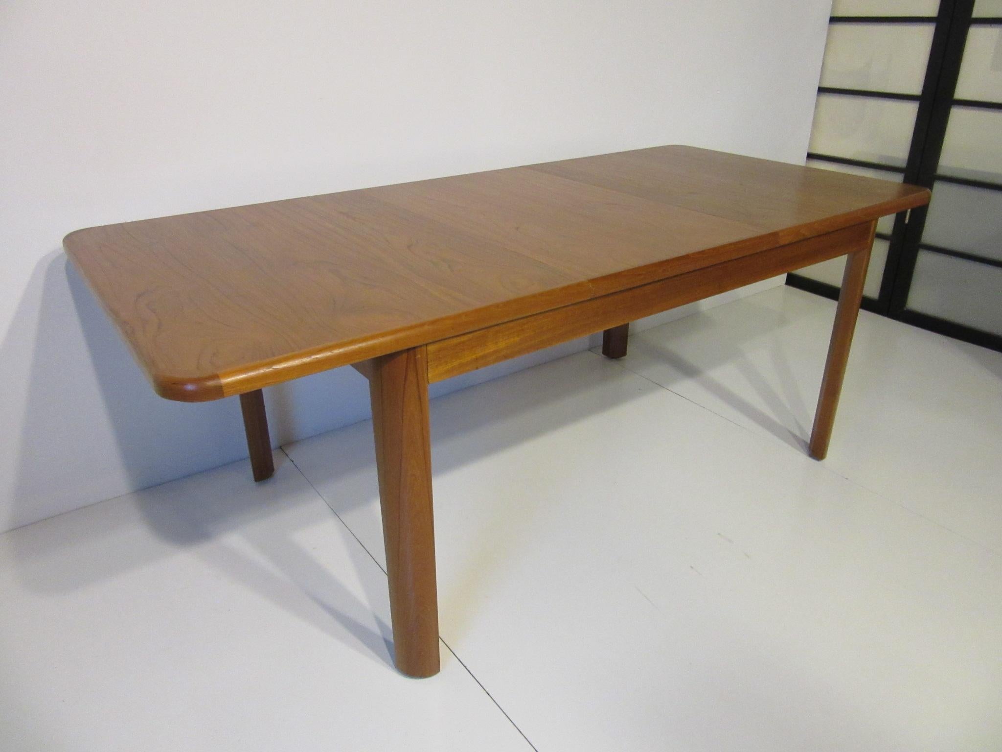 A well grained teak wood dining table with easy pull back table top for placement of one 21.75