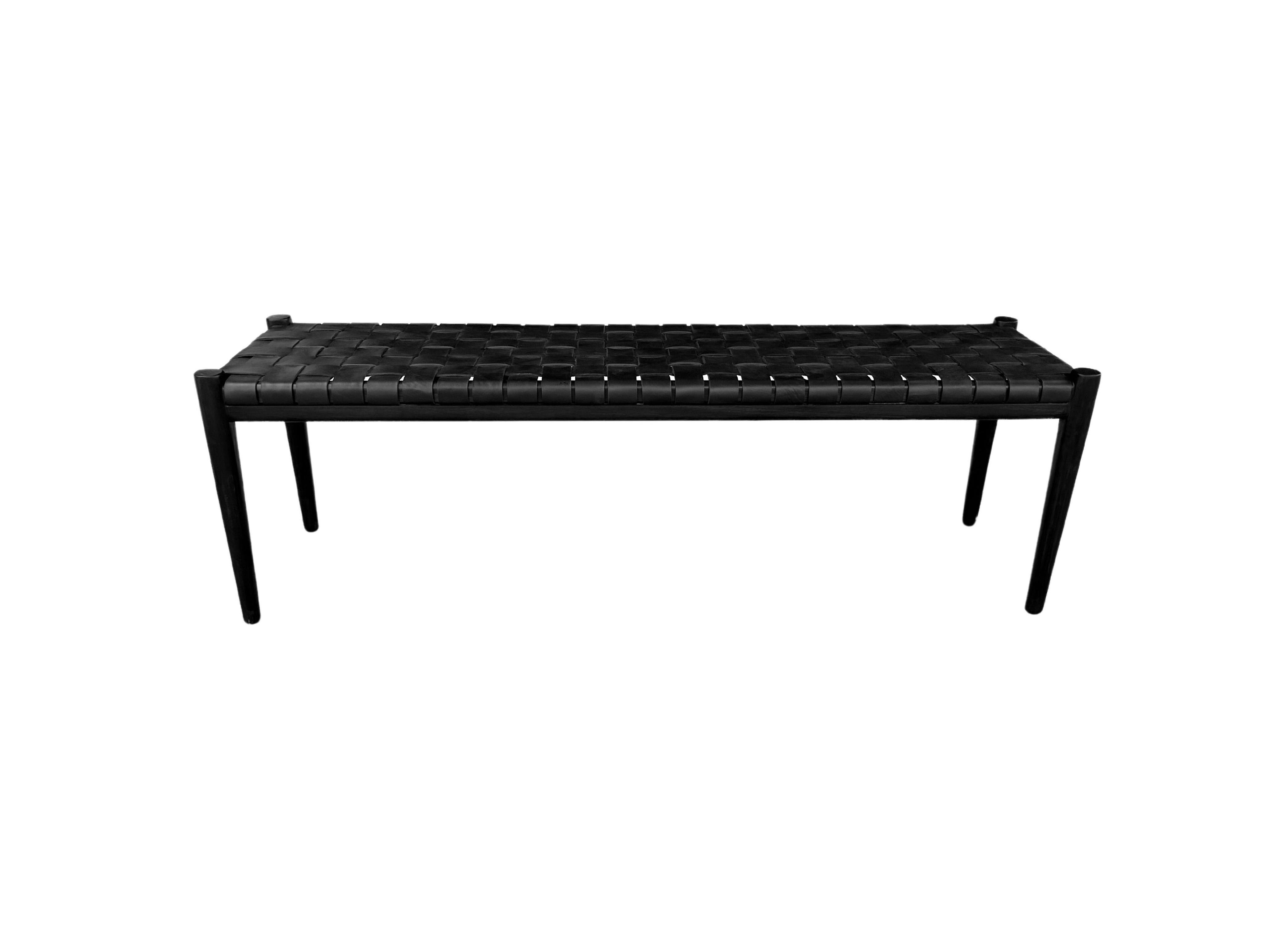 Banc artisanal avec cadre en teck et sangle en cuir tressé. Ces bancs sont fabriqués par des artisans locaux qui utilisent une technique d'assemblage du bois sans utiliser de clous. Ils présentent une texture boisée subtile et sont robustes. Ce banc