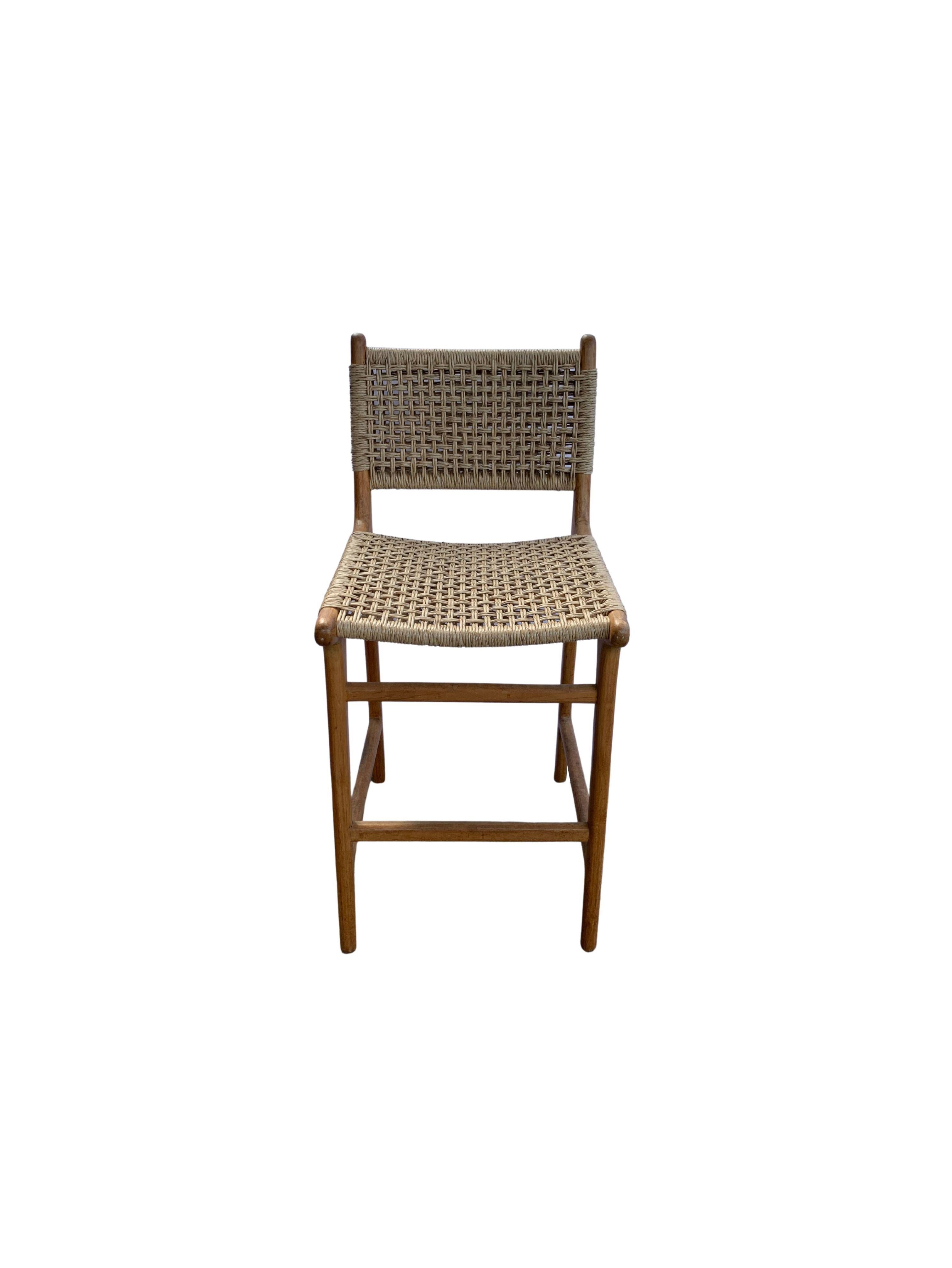 A hand-crafted teak framed & woven synthetic rattan stool. These stools are crafted by local artisans using a wood joinery technique without the use of nails. They feature a subtle wood texture and are robust and sturdy. Synthetic rattan is more low