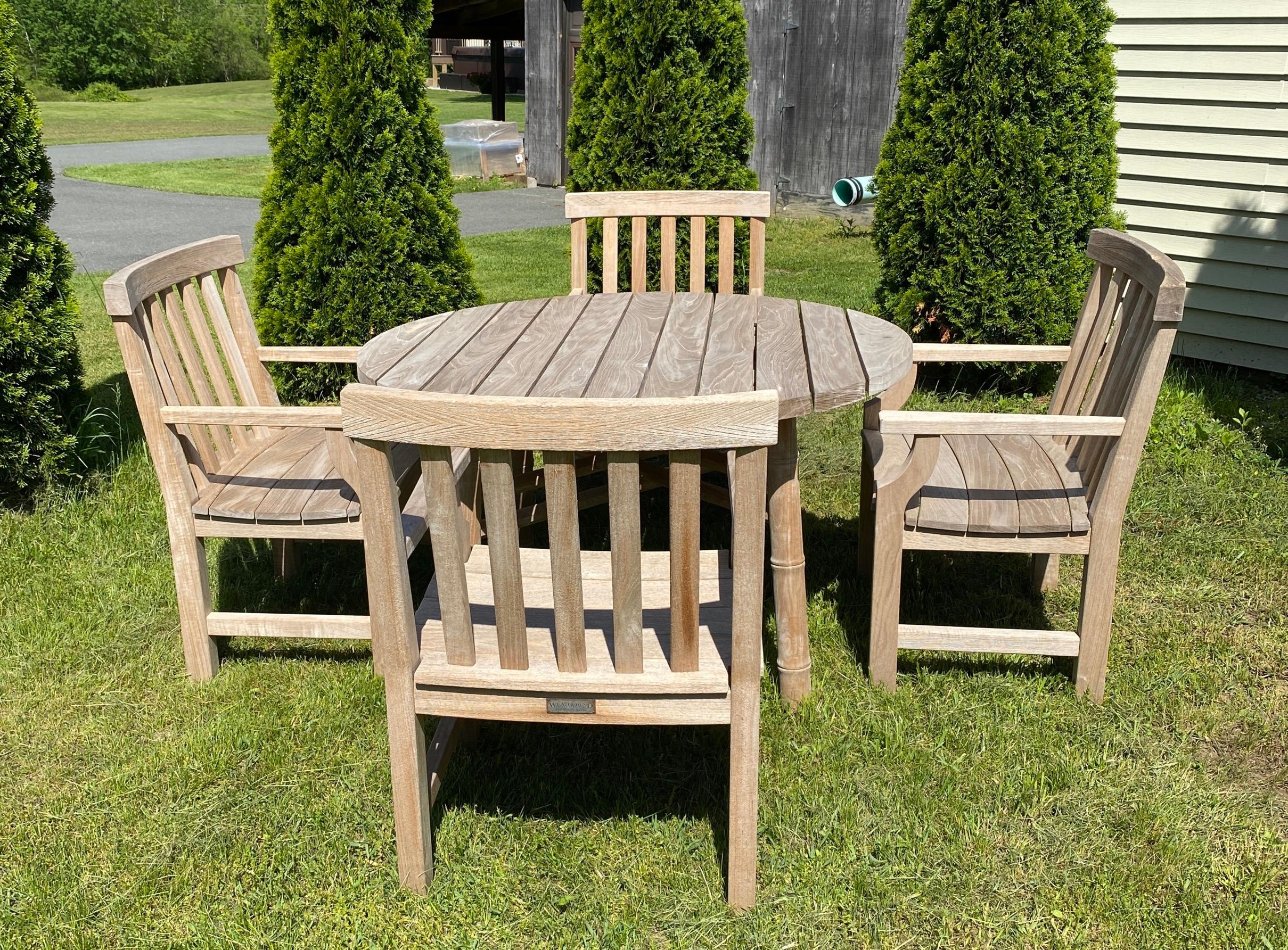 Vintage outdoor teak garden, porch or patio dining table with 4 armchairs. Table is made by McGuire having stylish faux bamboo legs, chairs with generous proportions for extra comfortable seating and dining. Table and chairs have recently been