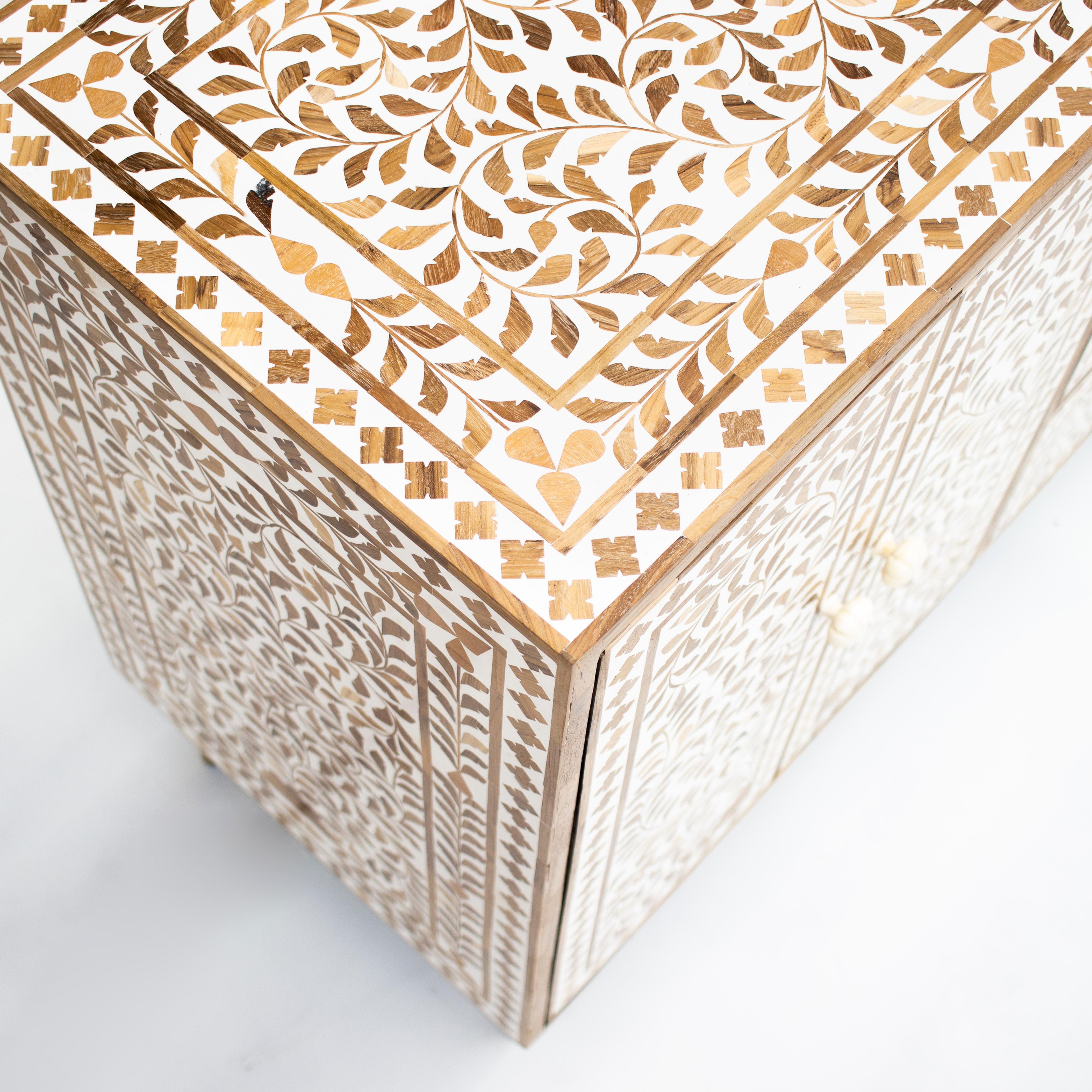Wir stellen Ihnen den exquisiten Teakholz-Schrank mit Intarsien vor, der nach der traditionellen Methode der Möbelherstellung mit Intarsien handgefertigt wird. Dieses atemberaubende Stück besteht aus verschlungenen Teakholzstücken, die kunstvoll zu