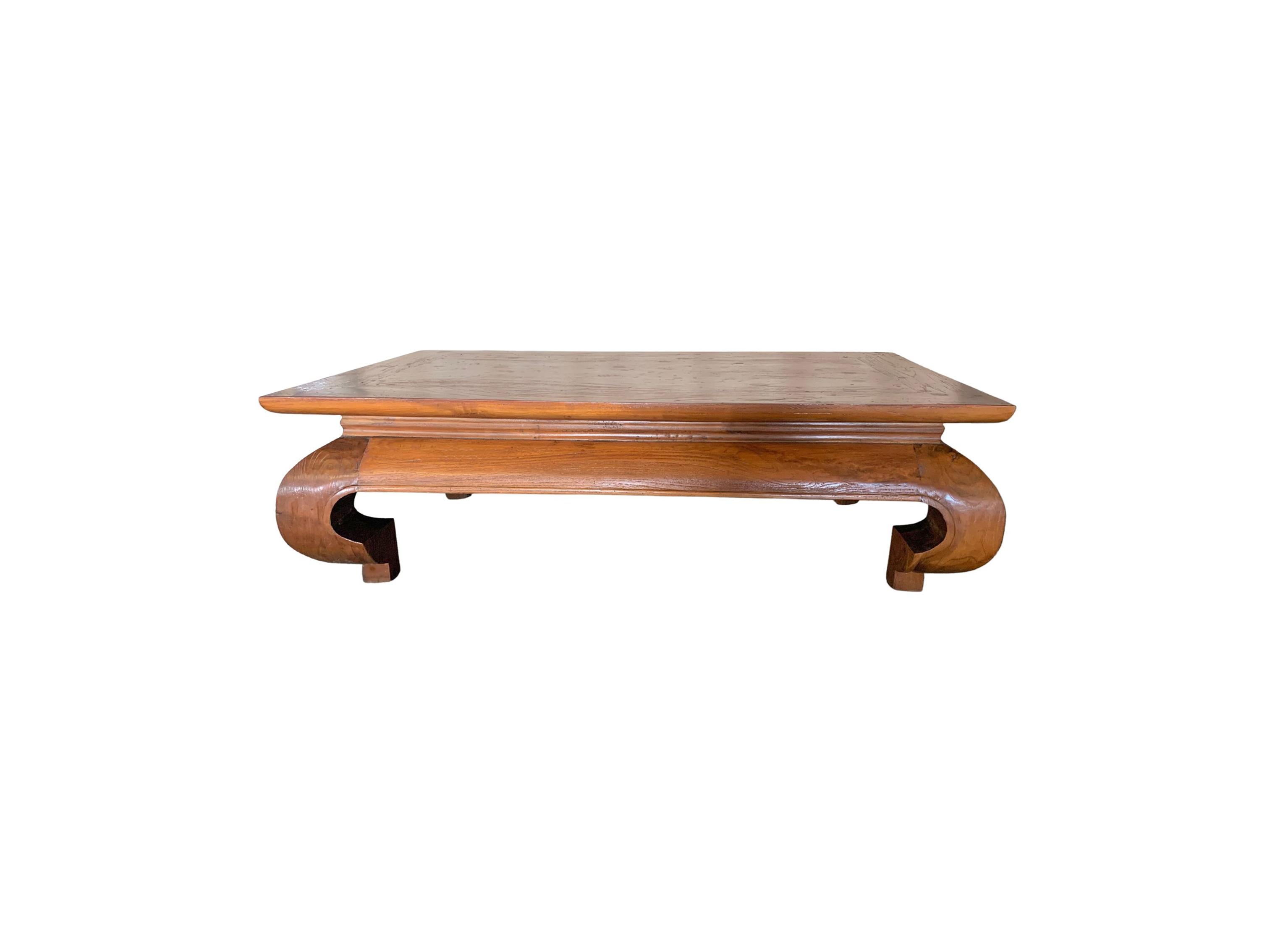 A wonderfully crafted teak wood low table with elegantly curved legs that blend with the table's contours. The mix of curved and straight lines add to this table's charm. A mix wood textures and shades are present on all sides.