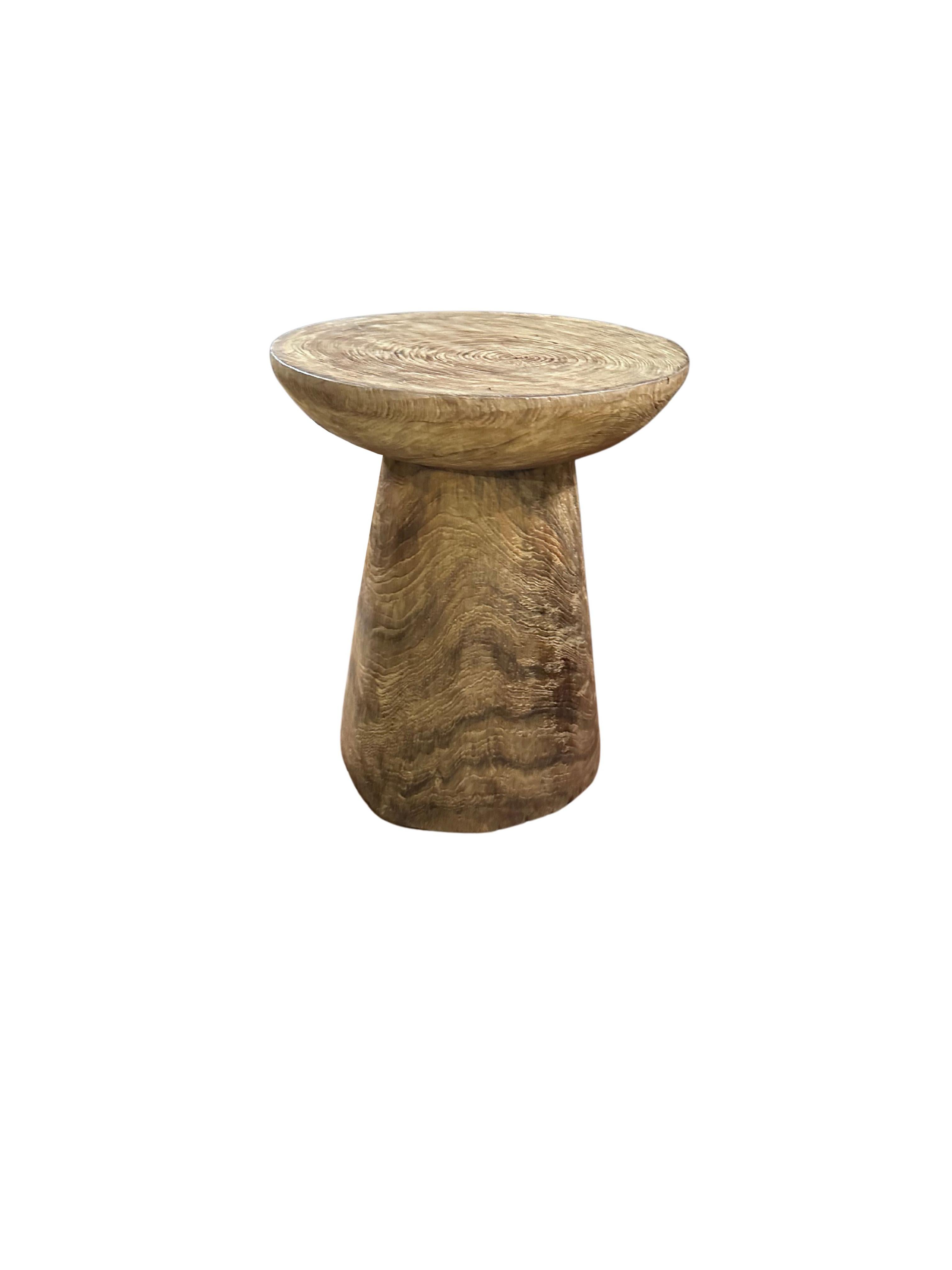 This exquisite teak wood side table is a stunning showcase of nature's beauty, with rich, intricate wood textures and warm, varying shades that make each piece truly unique. The table’s surface features a captivating grain pattern, where swirls and