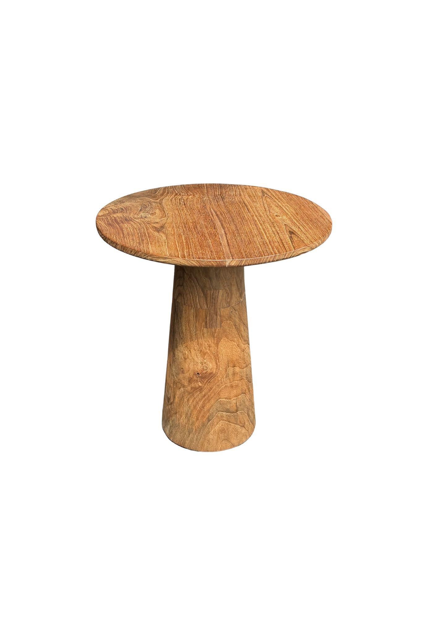 This exquisite teak wood side table is a stunning showcase of nature's beauty, with rich, intricate wood textures and warm, varying shades that make each piece truly unique. The table’s surface features a captivating grain pattern, where swirls and