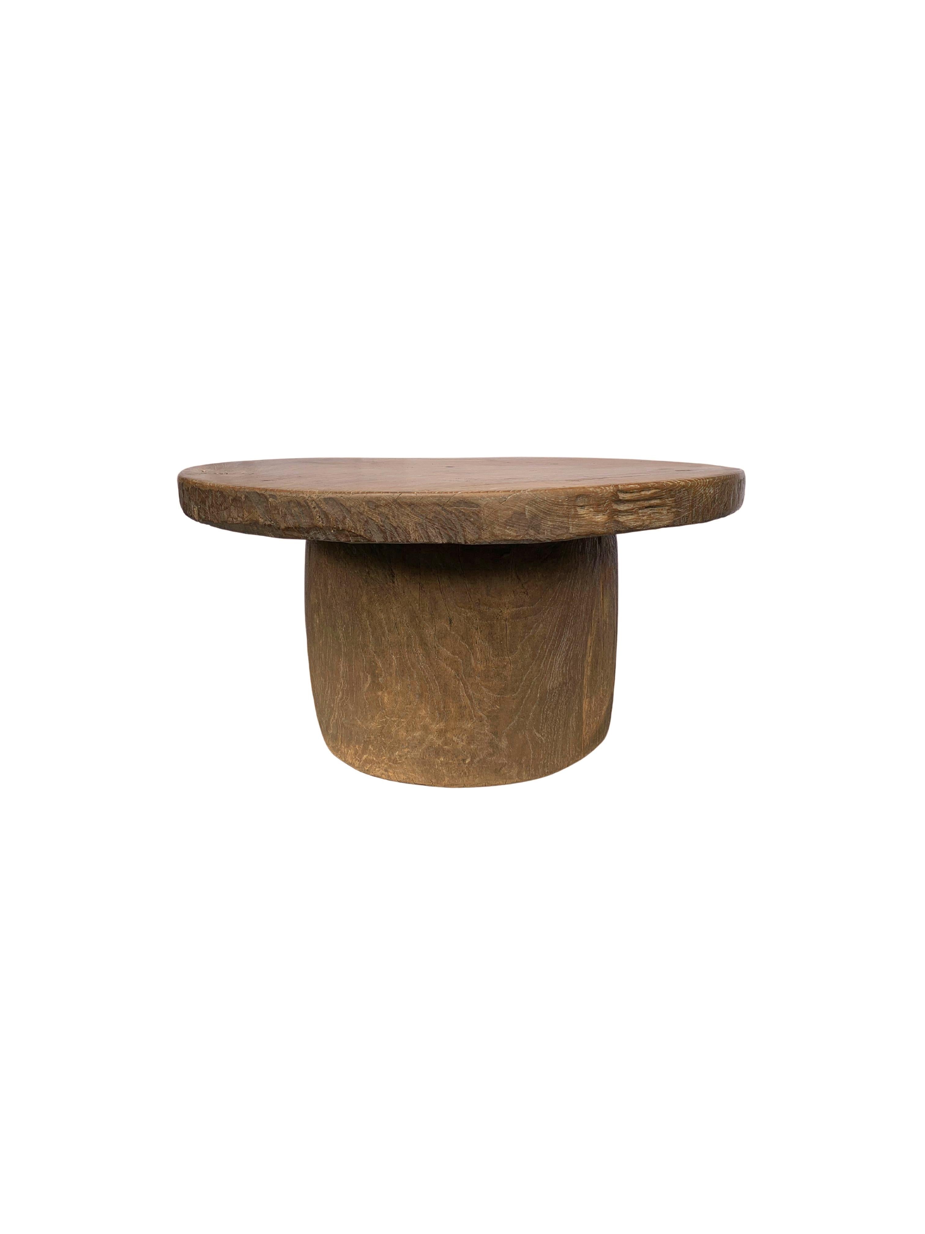 This teak round table was crafted on the island of Madura off the Northeastern coast of Java, Indonesia. It features a hollow base, that was crafted from a single block of wood. The Table top, which is solid and heavy was also crafted from a single