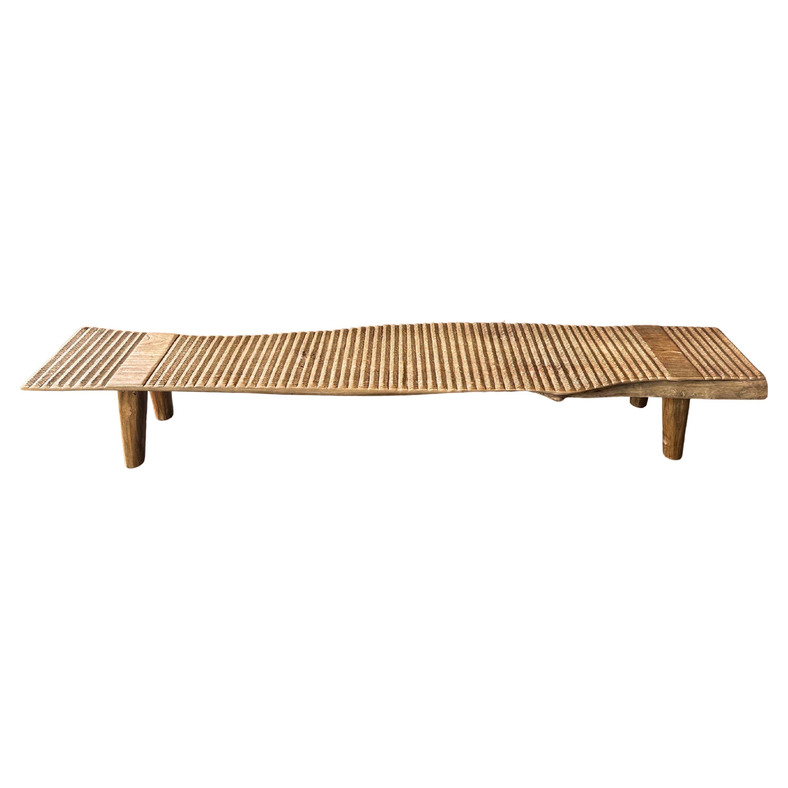 Banc long sculptural en bois de teck, détails sculptés, organique moderne