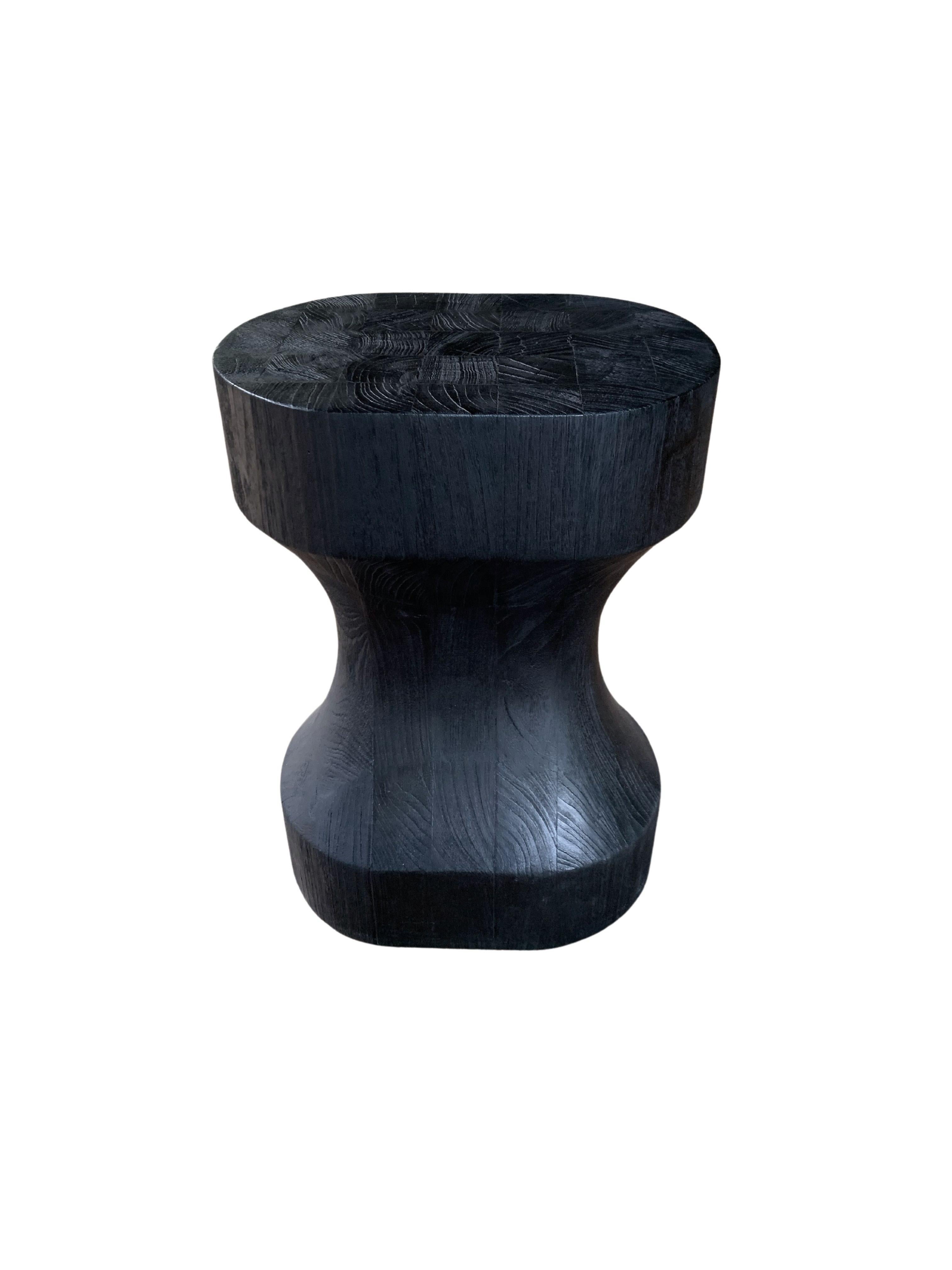 A wonderfully sculptural round stool. Its neutral pigment and subtle wood texture makes it perfect for any space. A uniquely sculptural and versatile piece certain to invoke conversation. It was crafted from teak wood and has a smooth texture and