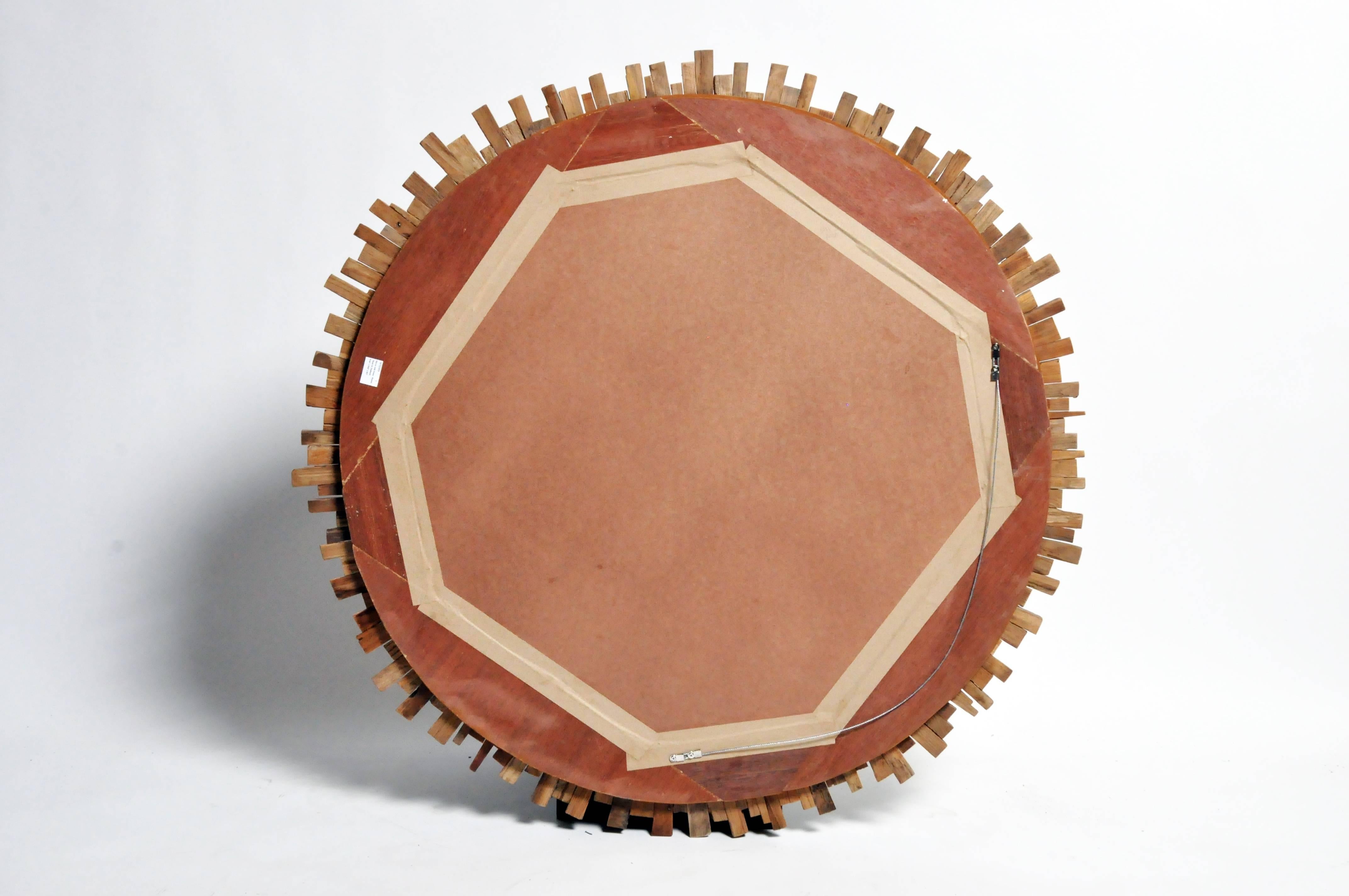 Natural strips of reclaimed teak radiate from a circular mirror plate. The raw, untreated wood almost has a driftwood-like quality to it; quite different than the Baroque gilt Italian mirrors that it is inspired by.