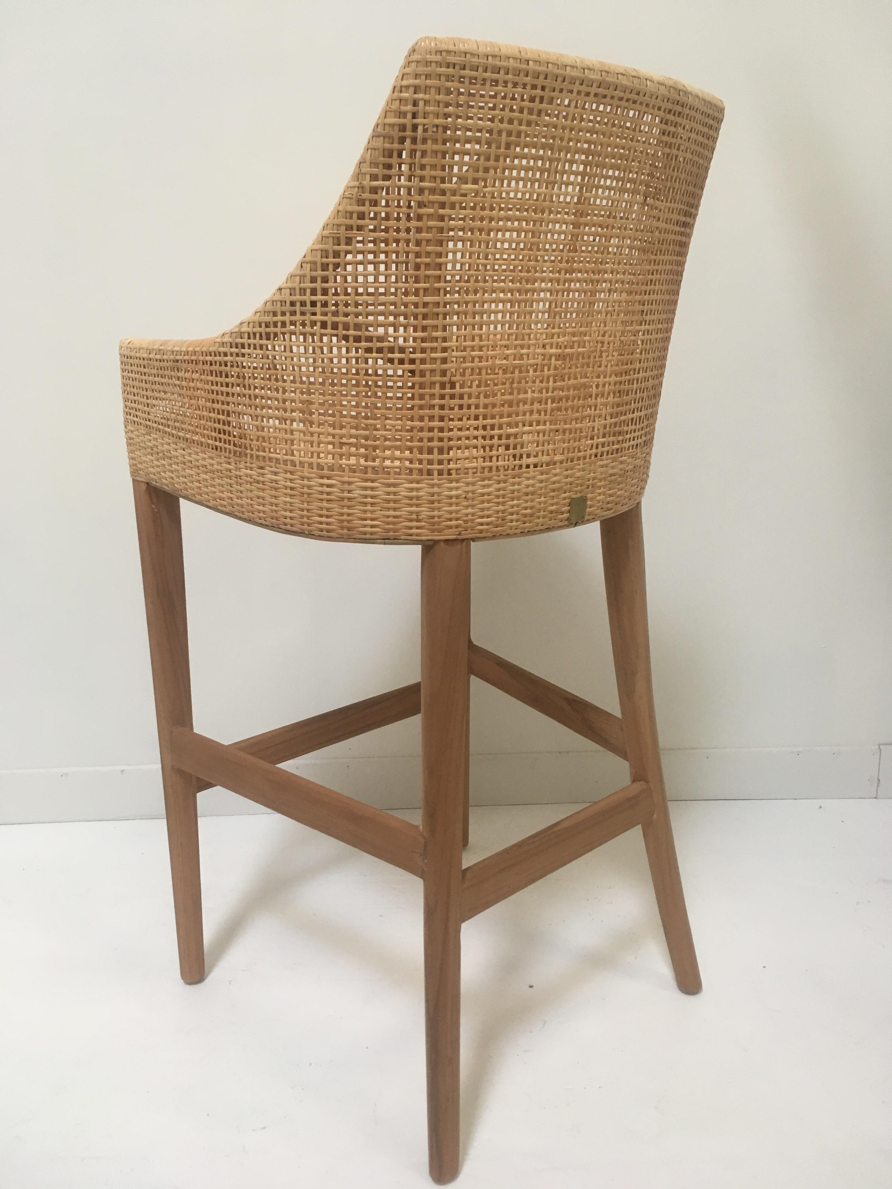 Elegant rattan bar stool with a structure in teak wooden and handcrafted braided rattan combining quality, robustness and class. Comfortable and ergonomic, aerial and poetic. The armrests height is 82cm and the seat height is 71cm. In excellent