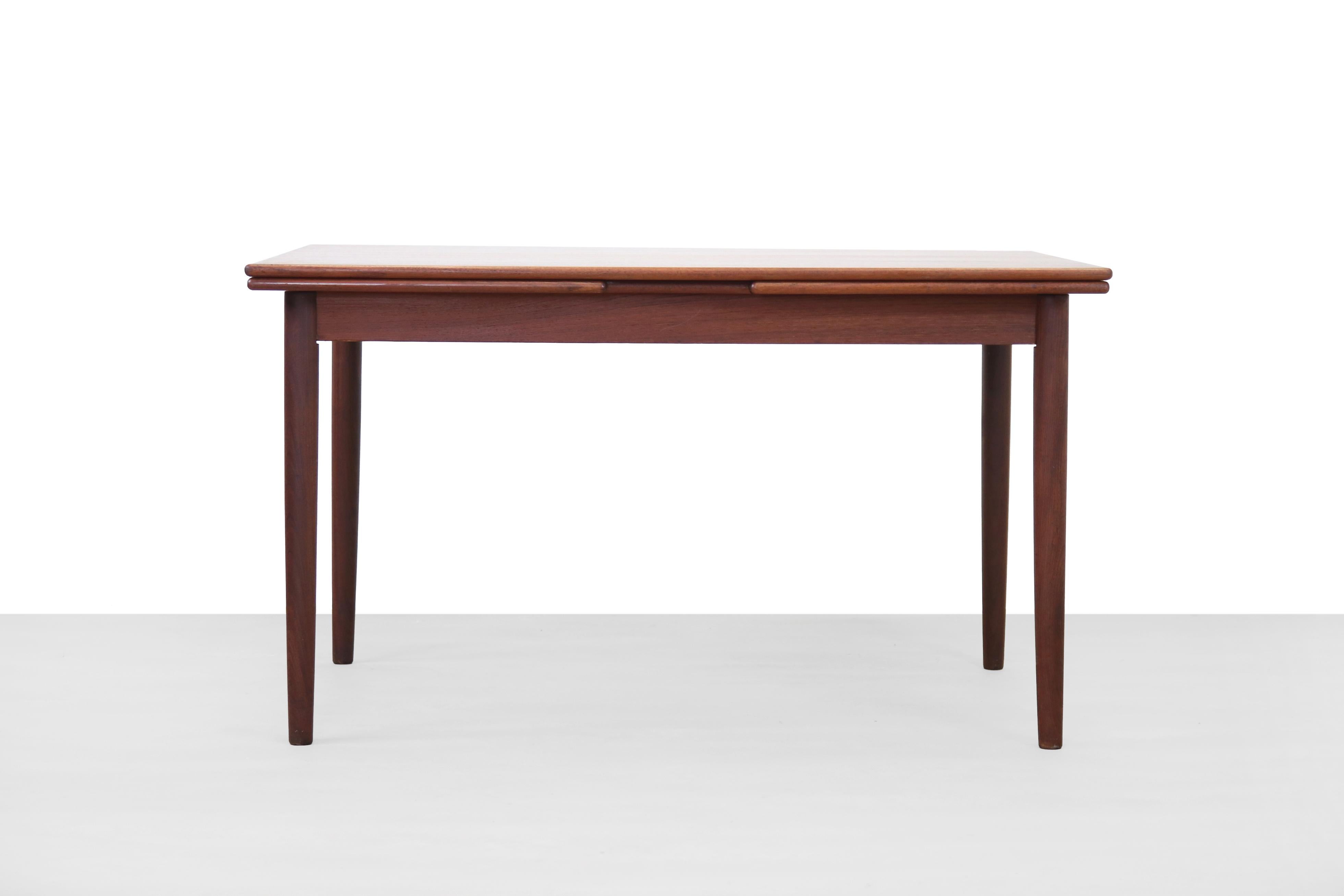 Vintage Danish extendable dining table made of teak. The extra blades are nicely integrated in the design, stored under the blade. The table tops are nicely rounded with solid teak wood edges. This table is 130 cm long, 86 cm deep and 75 cm high.