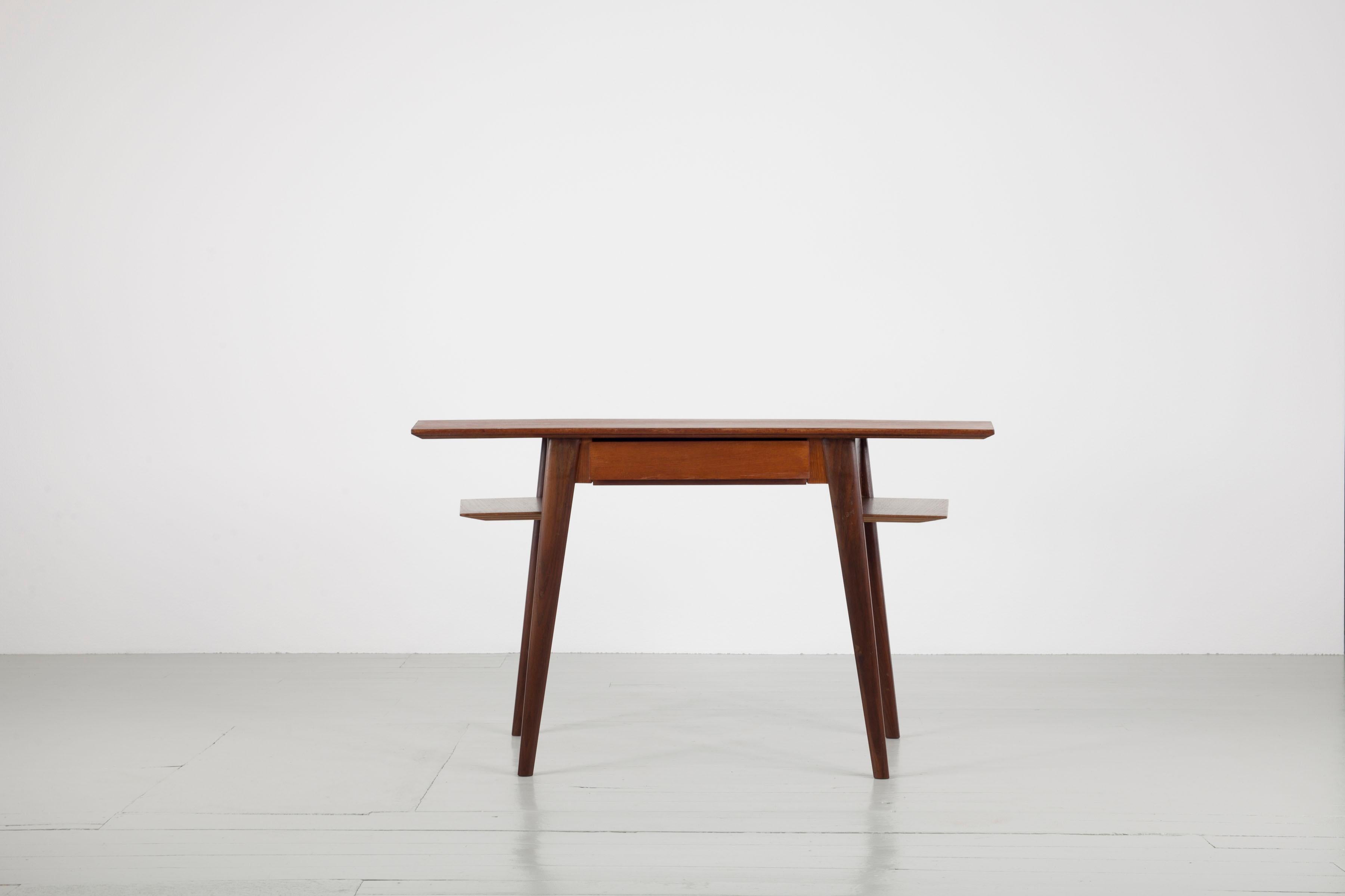 Writing desk, design by Silvio Cavatorta, Italy, 1960s. The teak desk has a shelf on either side and a drawer underneath the asymmetric table top.
The desk is beautiful on all sides - can be positioned also in the middle of the room.