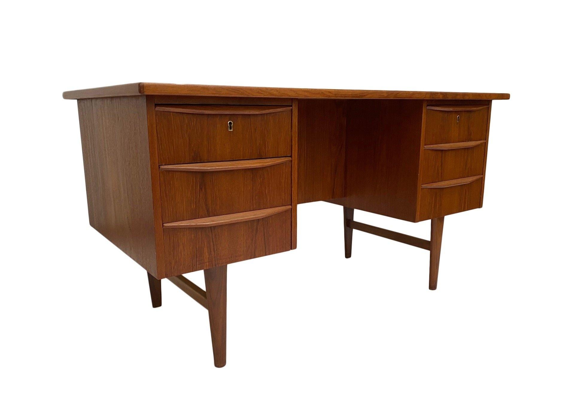 A beautiful Danish teak pedestal writing desk with scalloped handles, this would make a stylish addition to any work area. A striking piece of classically designed Scandinavian furniture.

The desk has two banks of three drawers, all are in good