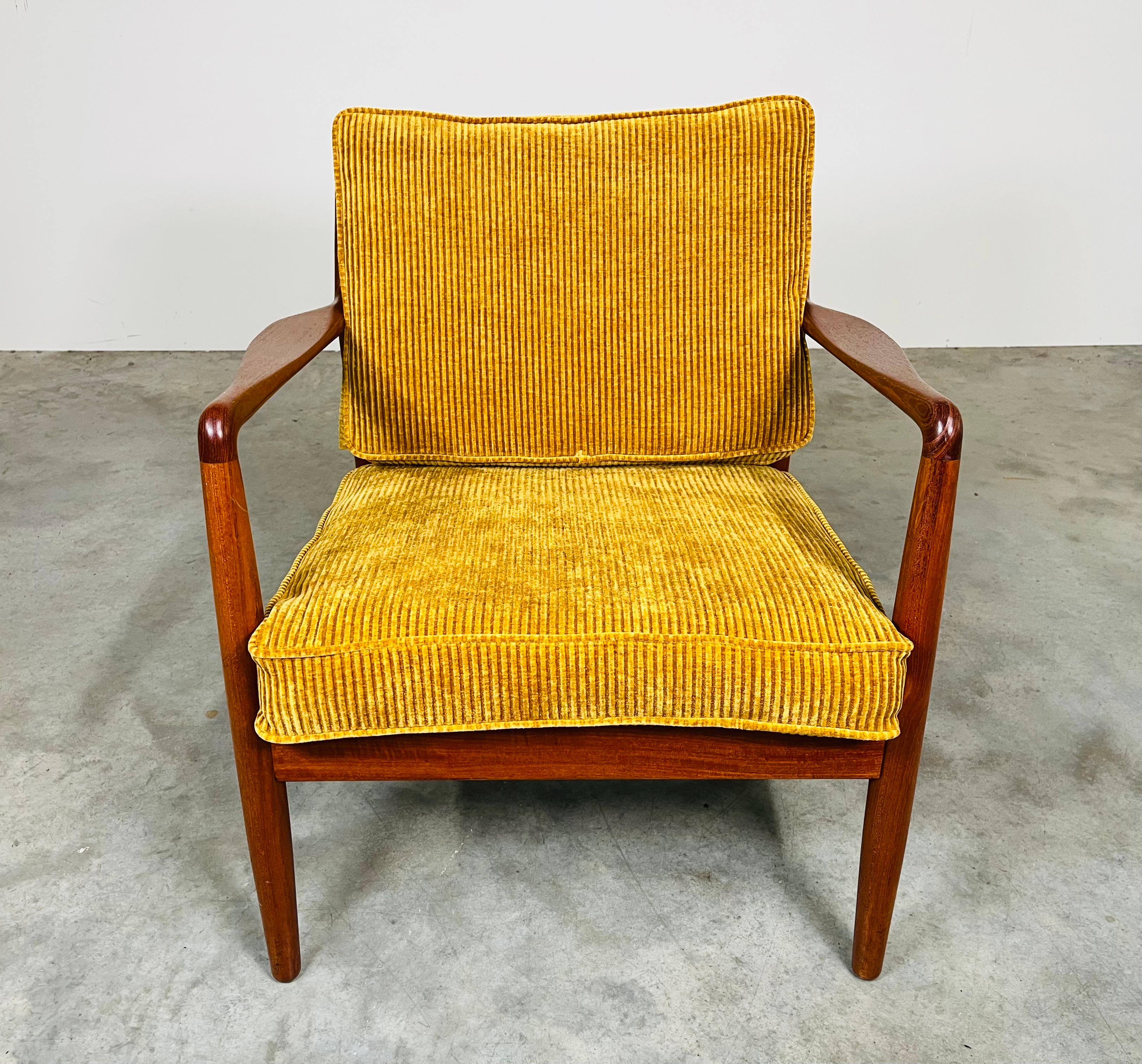 Scandinavian Modern solid teak lounge chair designed by Folke Ohlsson for DUX having hand carved armrests, newly replaced lattice rubber suspension with freshly upholstered deep yellow corduroy cushions. A very comfortable design with perfectly