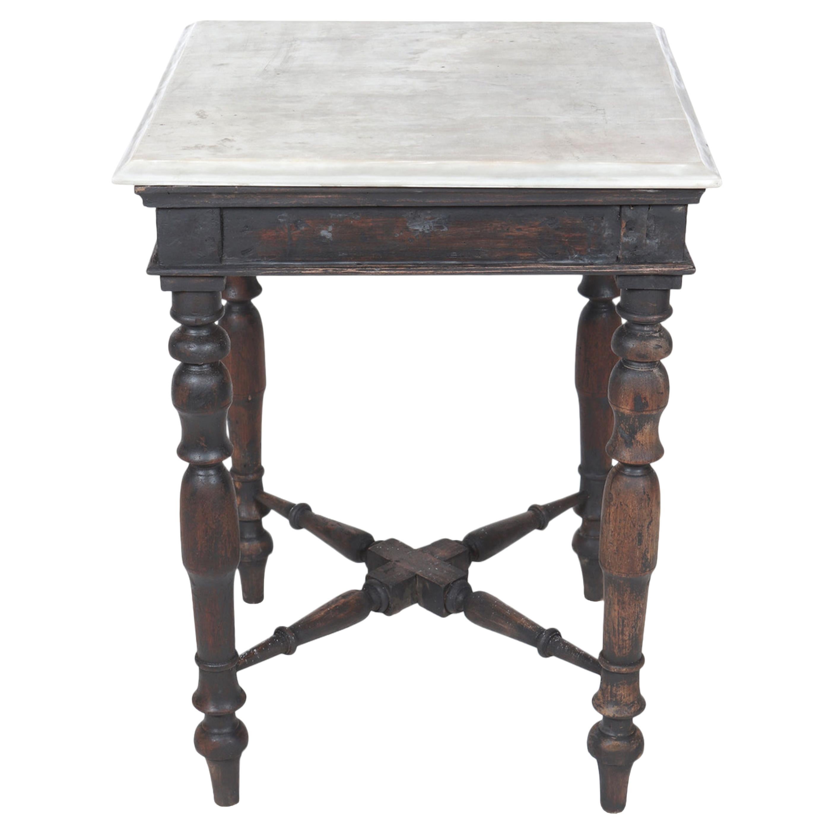 An exquisite teak marble topped side table. The table retains its original Italian beveled edge marble top, with beautifully turned feet and the original cross stretchers at the base.