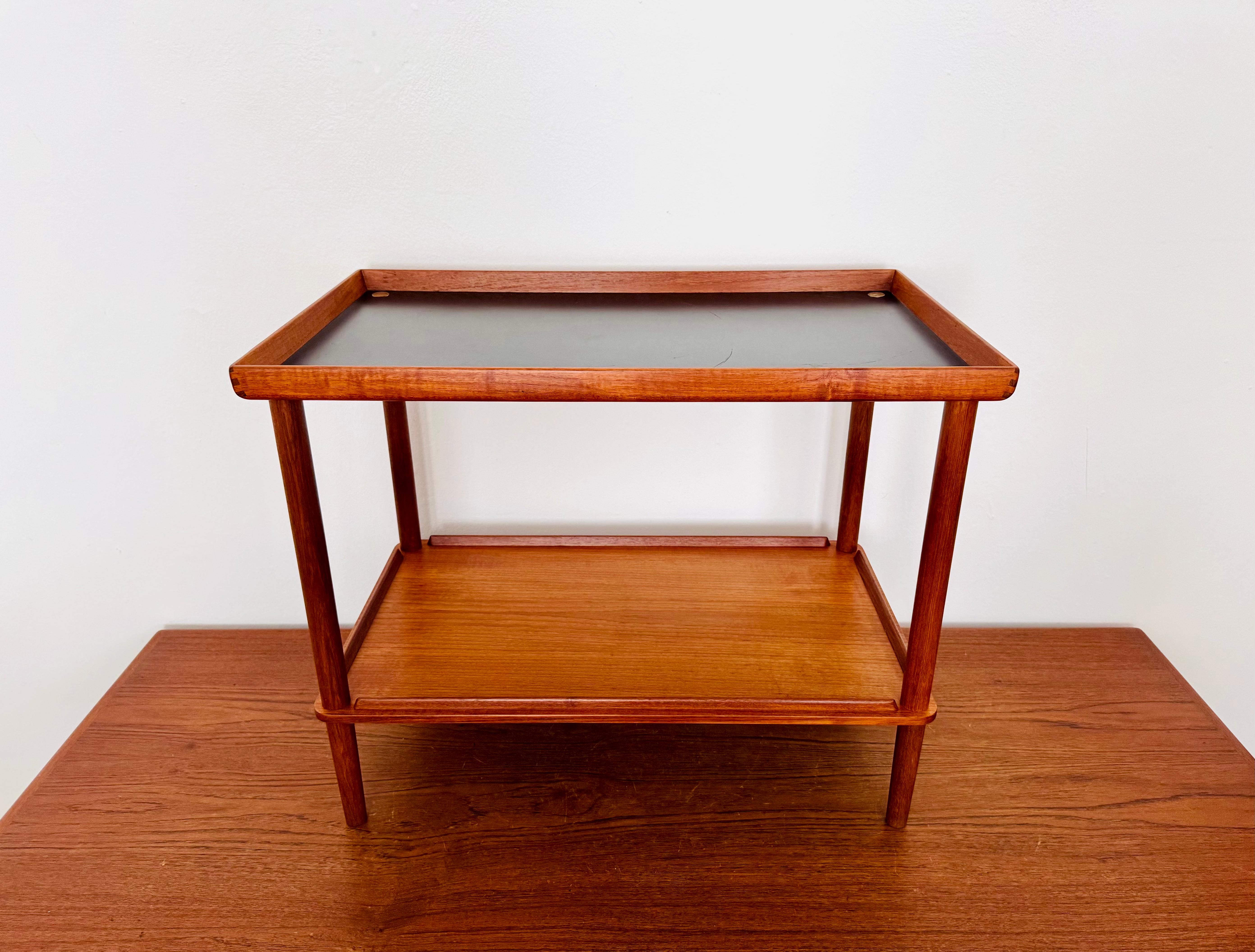 Excepcionalmente bella mesa auxiliar danesa de teca de los años 60.
La artesanía de alta calidad y el elegante diseño hacen de este pequeño mueble un auténtico favorito.
Destacan detalles encantadores como el borde elevado y las curvas