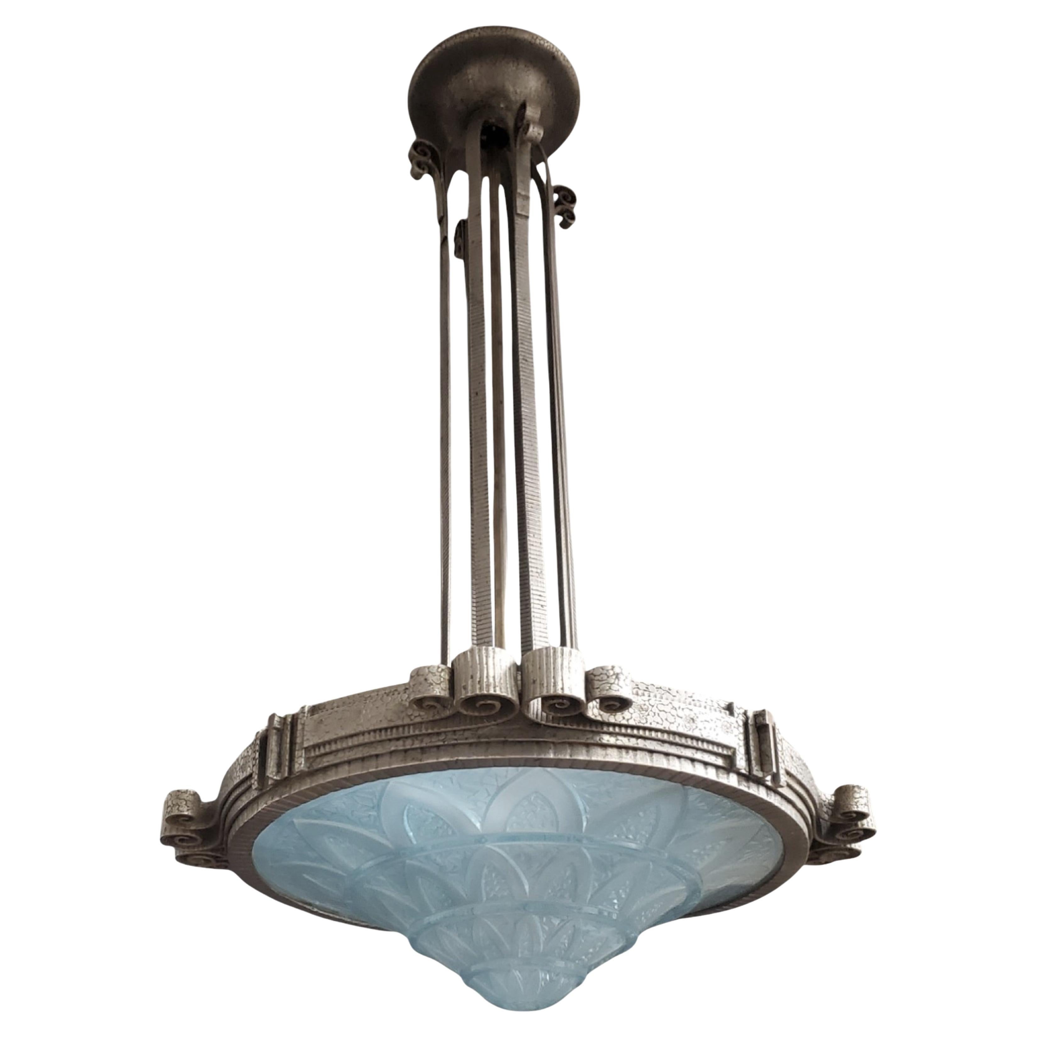 A striking French Art Deco chandelier attributed to Lorraine Nancy featuring a bold geometric design and exquisite craftsmanship. The clean lines of this fixture showcase a martele textured hand hammered iron / fer forge matt nickel finish with