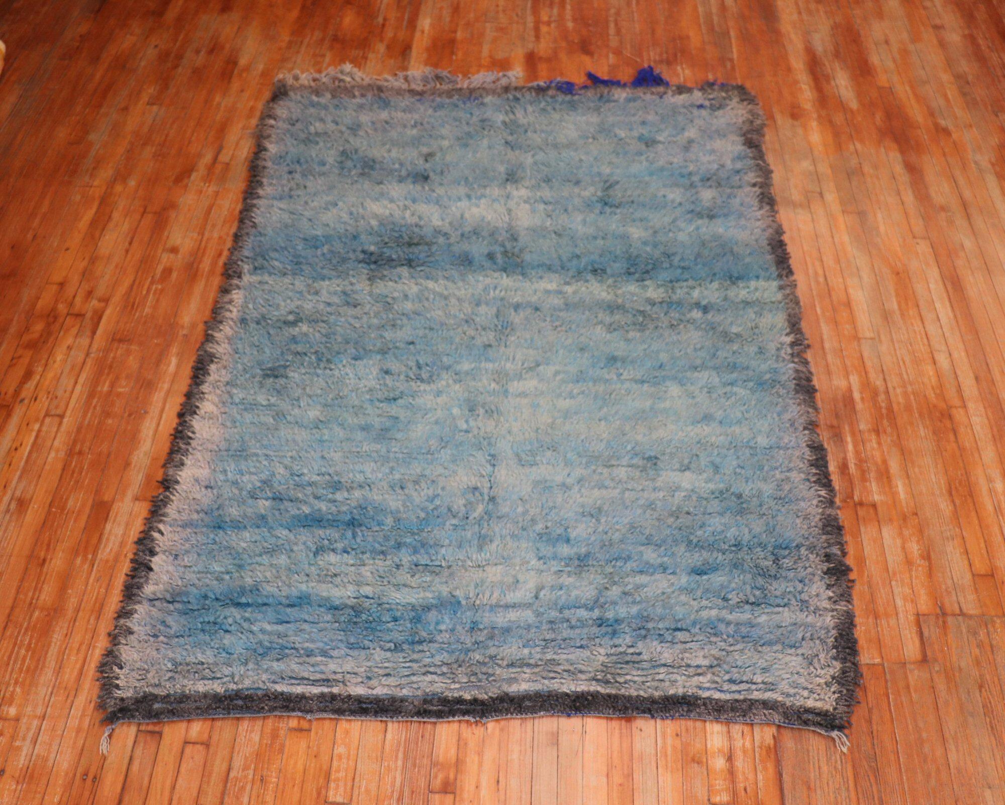 An authentic 20th century Moroccan rug with a Minimalist pattern in teal blue and striations of gray and brown surrounded by a sold gray border. Boho chic at its finest!


Size: 6' x 9'.
