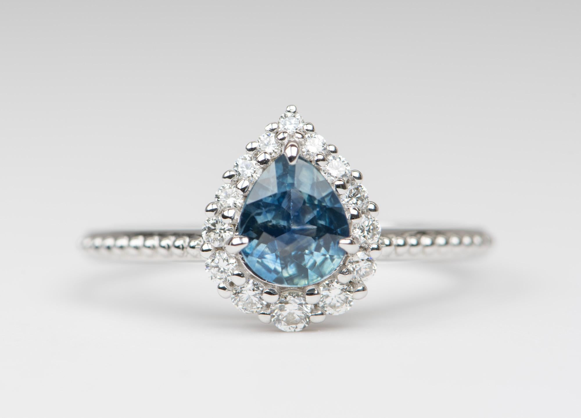 ♥  This is a solid 14K white gold ring set with a beautiful teal blue pear-shaped Montana sapphire in the center, flanked by a halo of gradual-sized sparkly diamonds. 
♥  The overall setting measures 9mm in width, 11.1mm in length, and sits 6.1mm