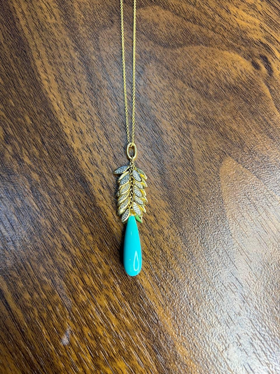Enhance your elegance with this stunning necklace featuring a delicate gold chain and a unique pendant design.
The pendant showcases intricate leaf-like elements adorned with sparkling accent diamonds, leading to a striking turquoise teardrop that