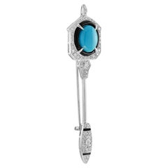 Spilla in oro bianco di ispirazione Art Deco con diamante e onice blu verde acqua.
