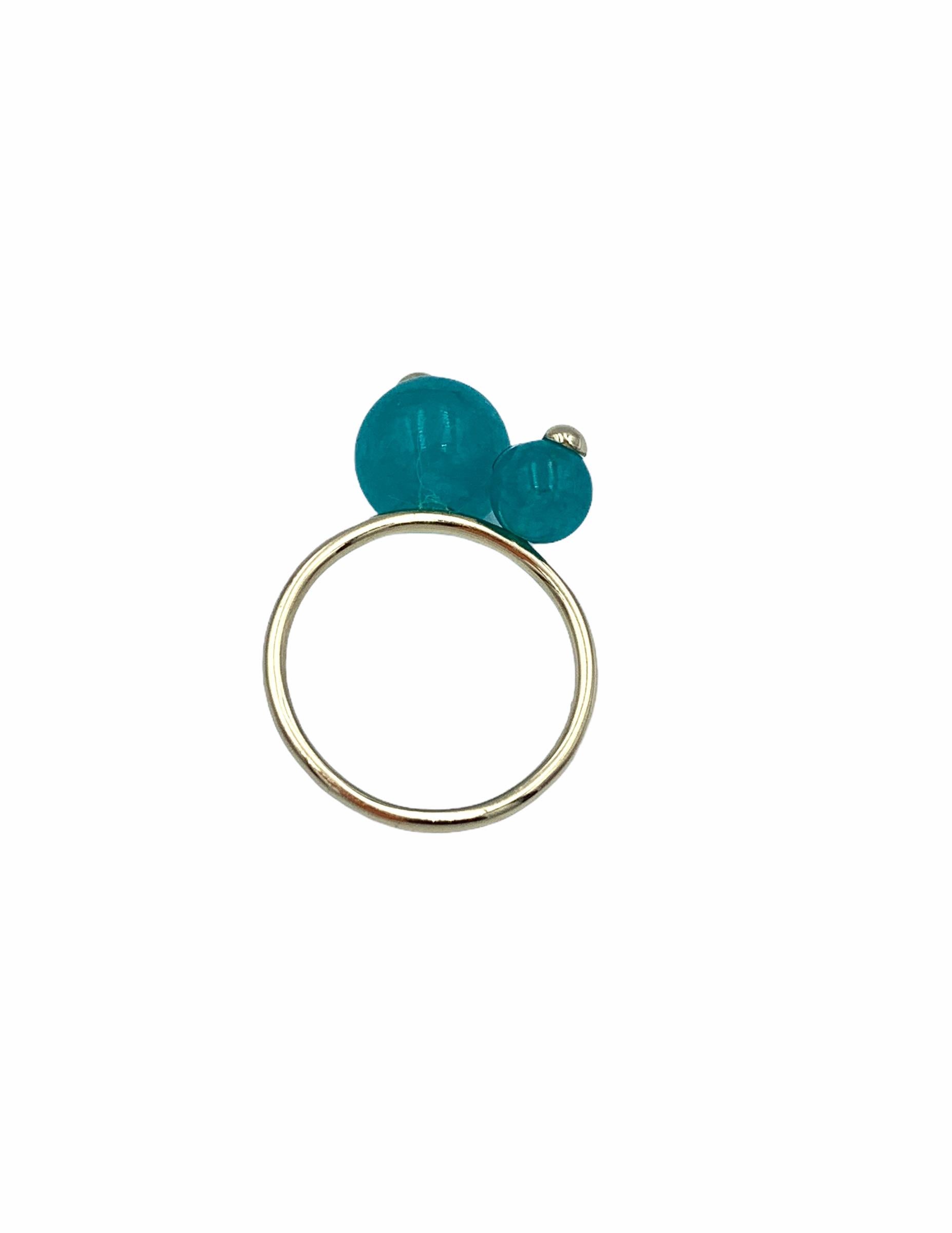 Hand made using 9 carat Yellow Gold, the two sized Chalcedony beads are threaded trough with a solid gold wire and soldered onto a delicate ring. The large teal beads is 10 mm, the following next to it is 6 mm, they both have a little yellow gold