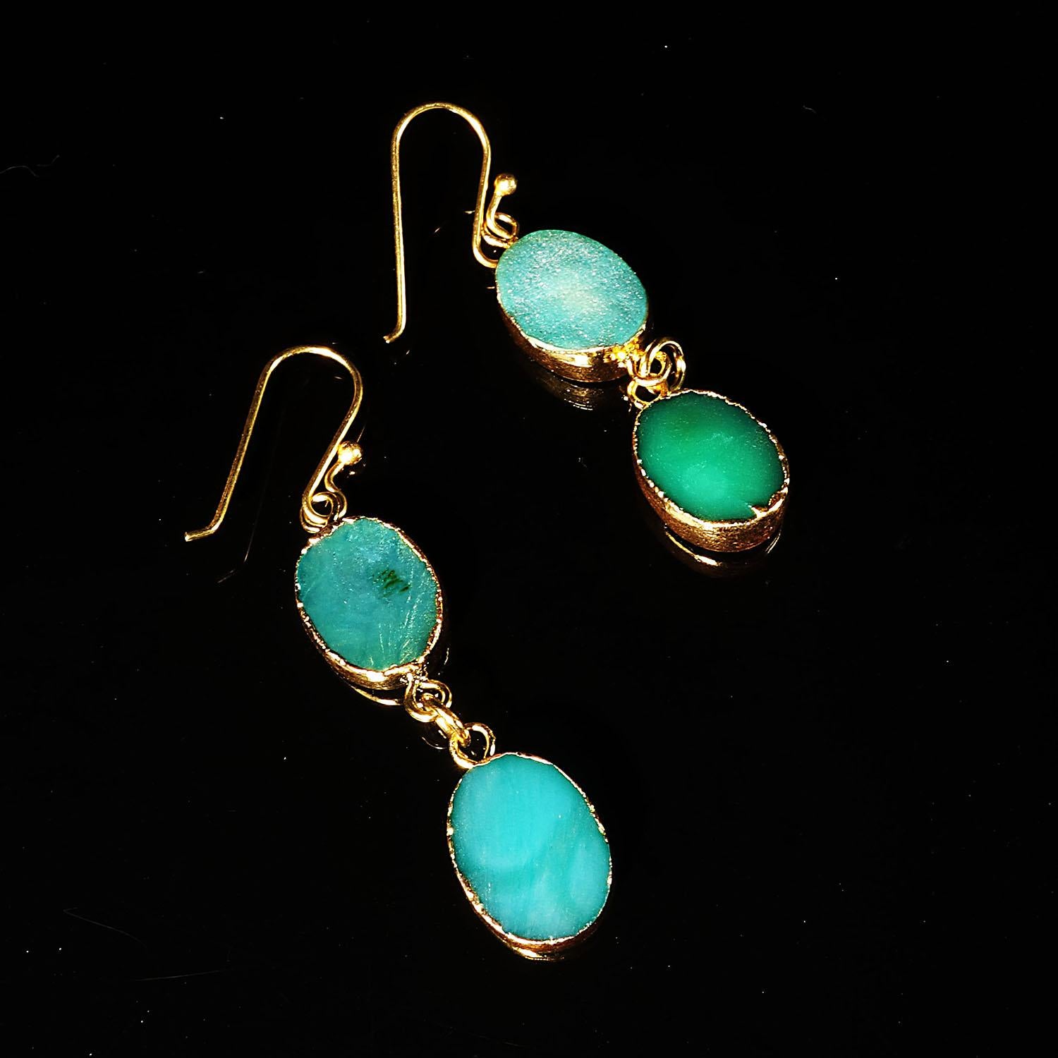 Delightful double dangle teal color Druzy earrings. These fun summer earrings each consist of two oval teal colored Druzy with goldy tone bezels. They hang from gold plated long hooks.  The entire ensemble is fun and funky.  They swing and dance