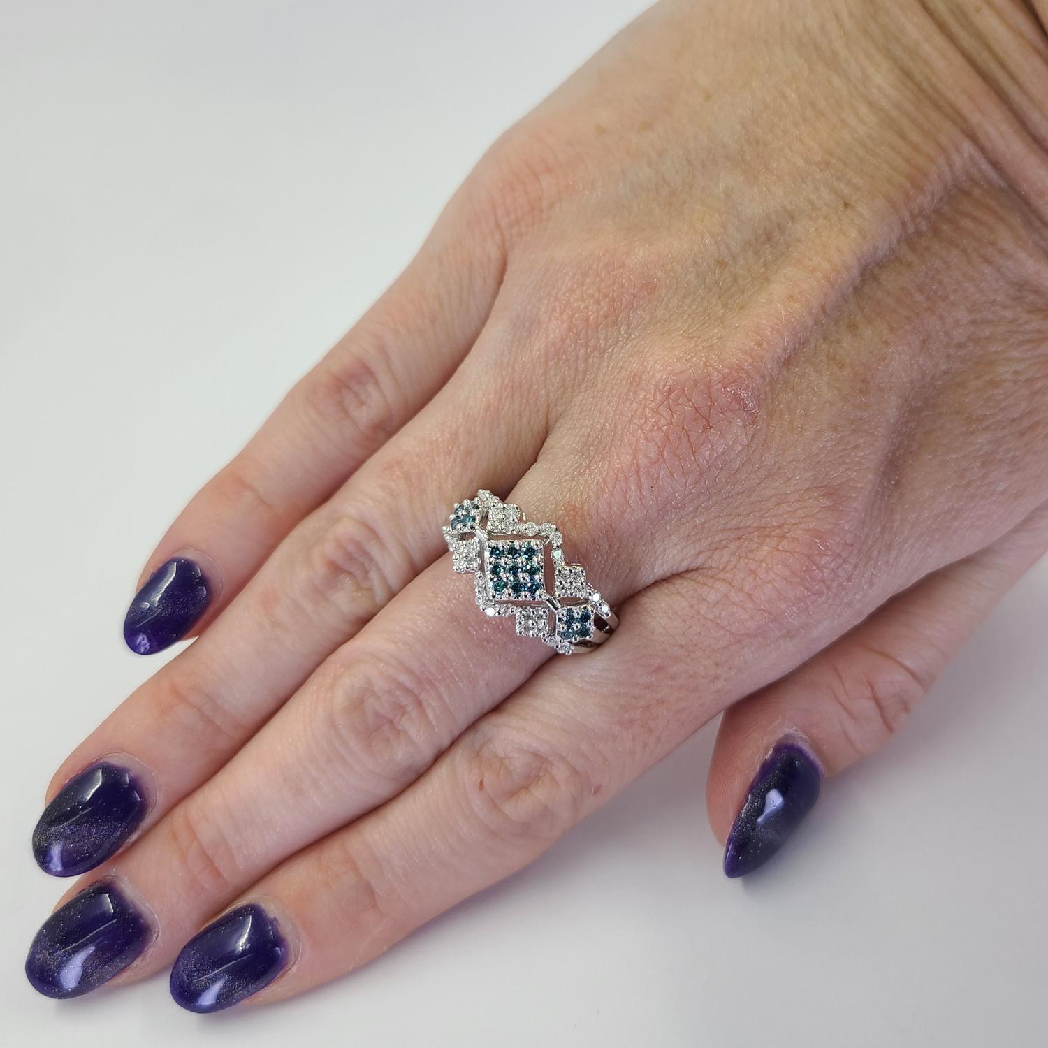 Fun 14 Karat White Gold Ring Featuring 17 Round Treated Teal Diamonds Totaling 0.17 Carats Accented By 32 Round Brilliant Cut Diamonds of SI Clarity and H/I Color Total 0.16 Carats. Current Finger Size 8.5; One Free Sizing Service Included with
