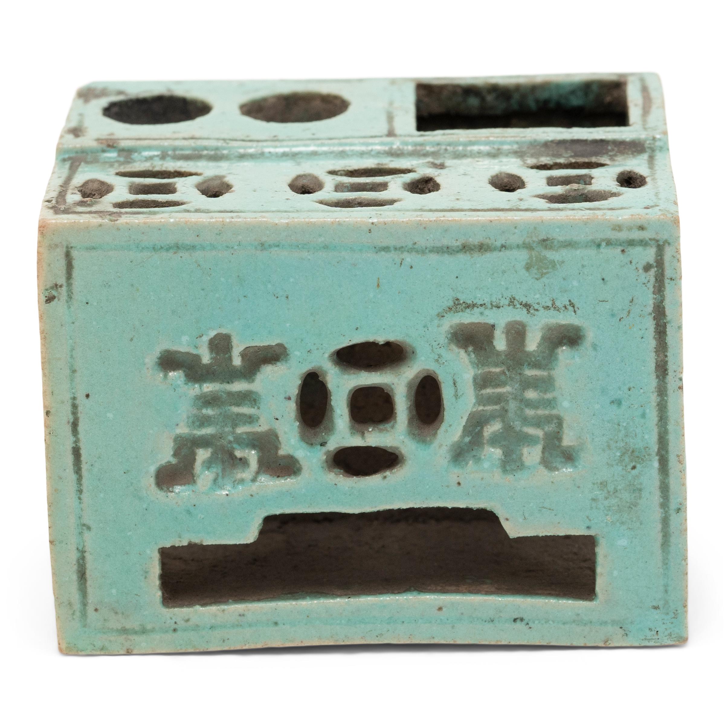Set alongside the four treasures of the study - the calligraphy brush, ink, paper, and inkstone - a brush rest was an essential fixture of the scholars' desk. This early 20th century ceramic brush rest is bathed in a speckled turquoise glaze