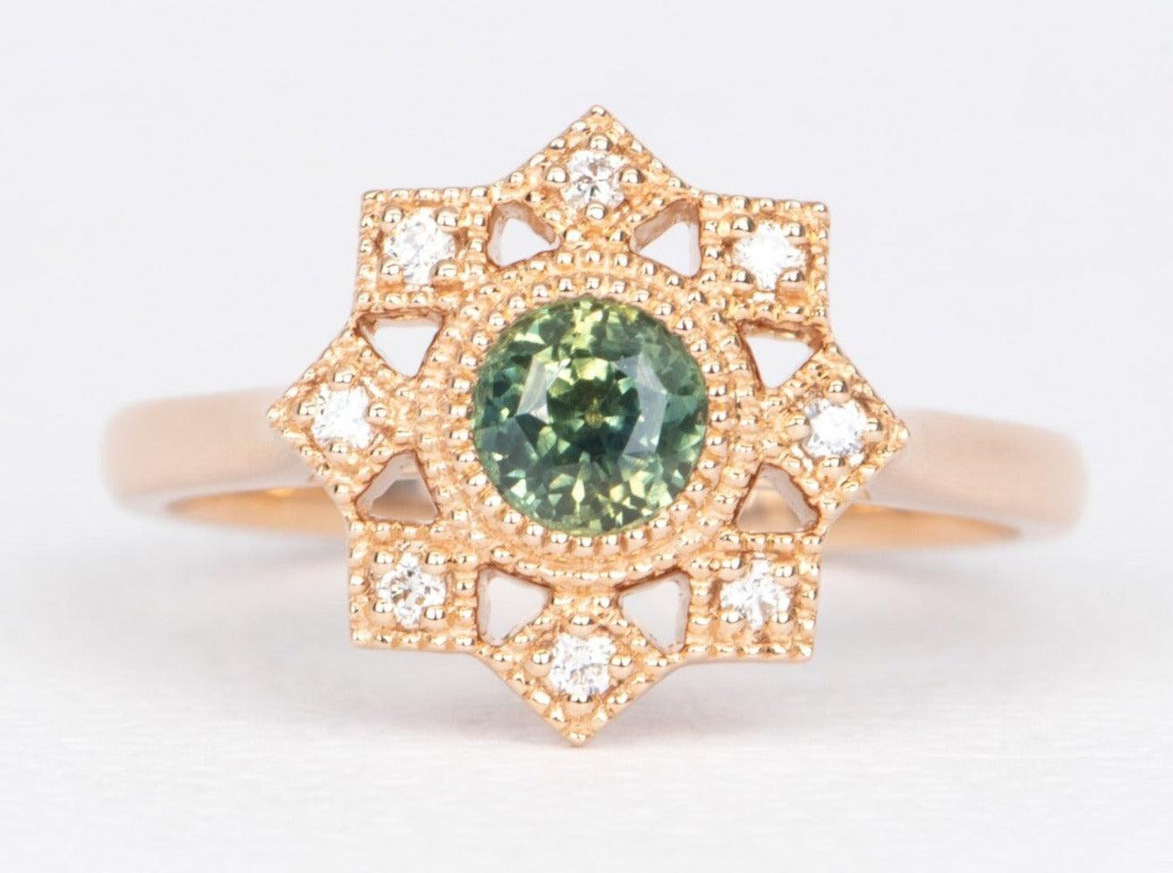 ♥ A solid 14K rose gold ring set with a round teal green Montana sapphire in the center with a milgrain diamond halo
♥The setting measures 12.9 mm in length, 13 mm in width, and sits 5.8 mm tall on the finger

♥ Solid 14K rose gold
♥ Band width: 2