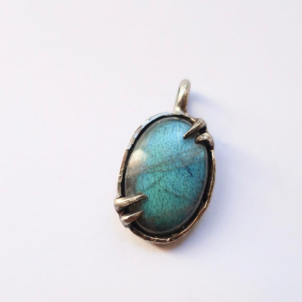 Hand Fabricated thick sterling silver setting with pointed prongs. This beautiful teal tone labradorite stone measures  12.80 x 19.40 x 8.40 mm. This is perfect to fasten on your favorite chain. The teal flash of color in the light is undeniably