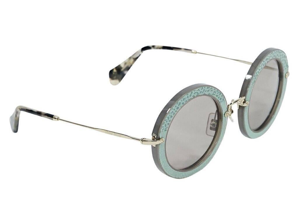 Product details:  Teal embossed suede round sunglasses by Miu Miu.  Cushioned nose pads.  Goldtone hardware.  Original case included.  2