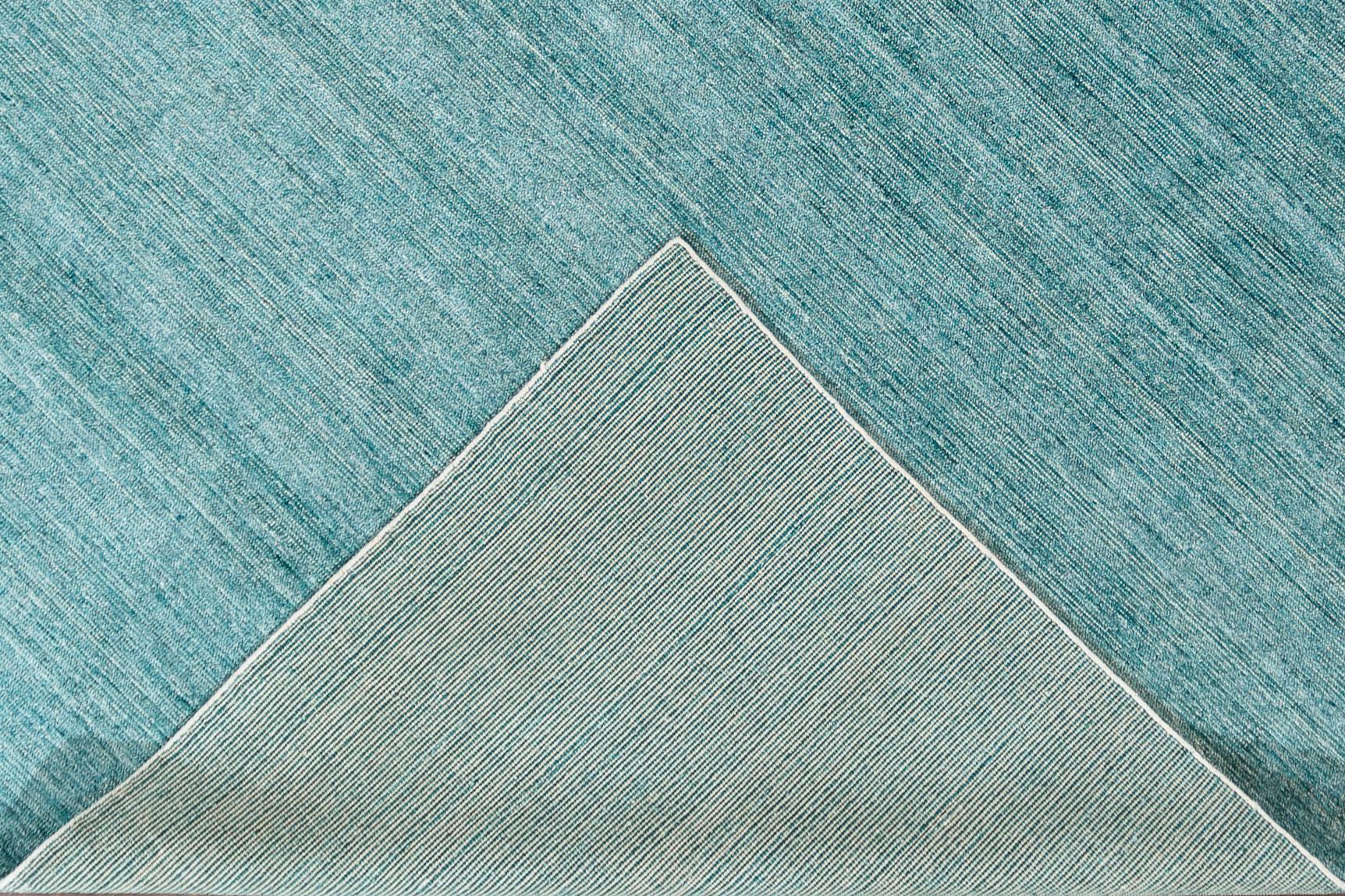 Magnifique tapis bohème indien moderne en bambou et soie, fait à la main, avec un champ sarcelle et ivoire. Ce tapis de la collection Boho présente un motif uni sur toute sa surface.

Ce tapis mesure : 9'0