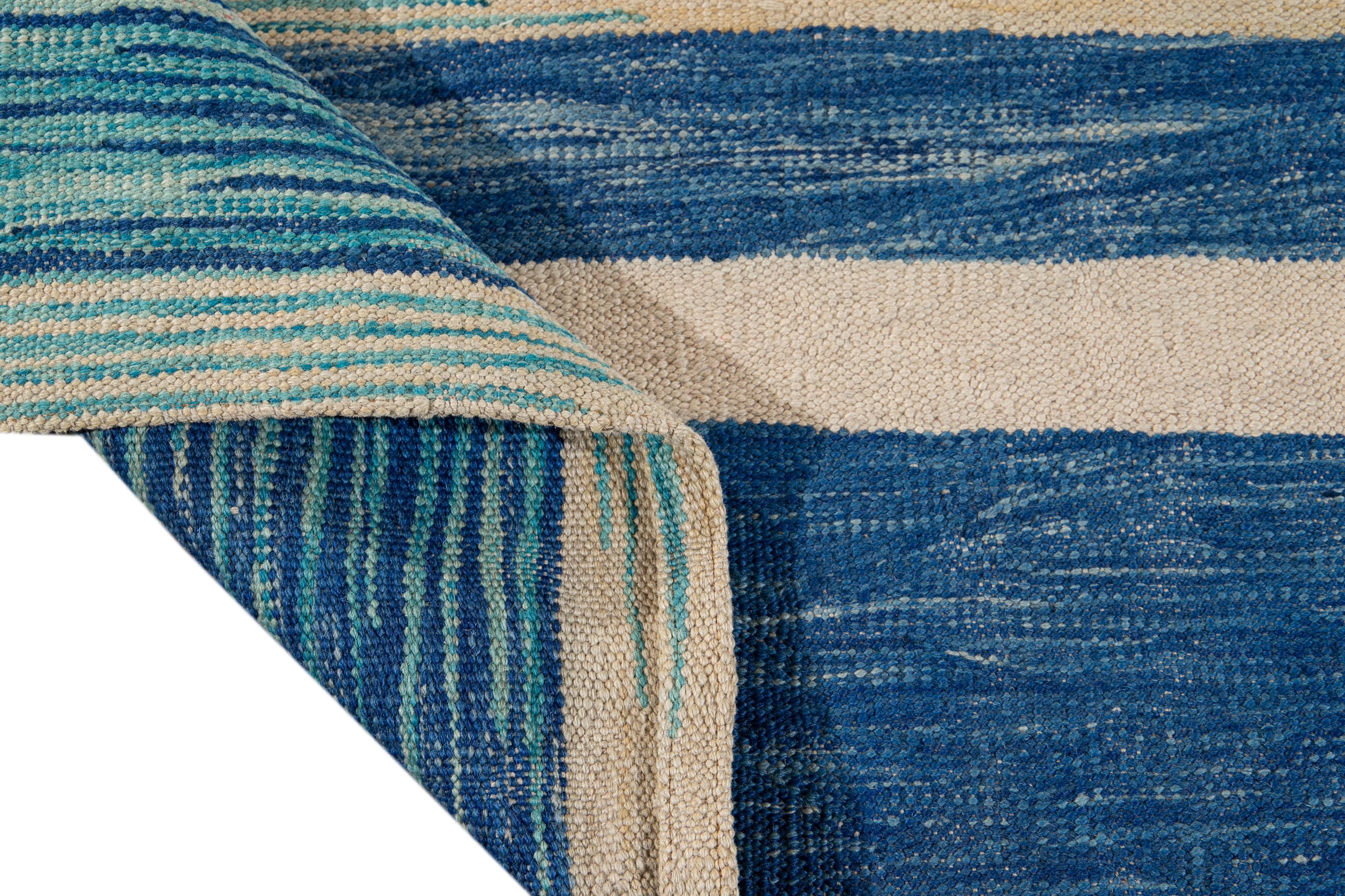Beautiful modern flat-weave Kilim handmade wool rug with a beige field. This Kilim rug has accents of teal and blue in a gorgeous geometric expressionist design.

This rug measures: 8'10
