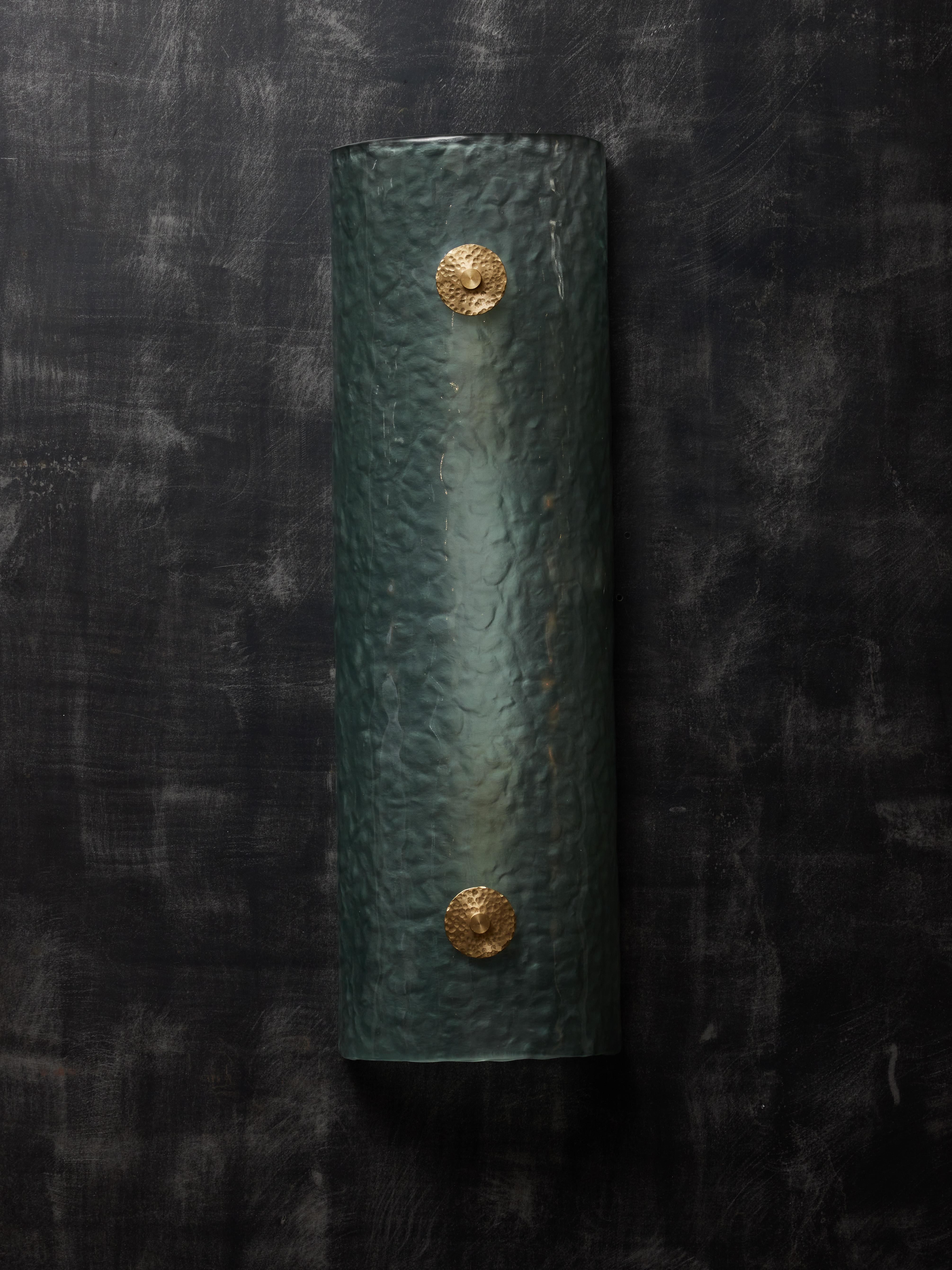 Teal curved Murano glass wall sconces with hammered brass washers.

Two sources of light per sconce