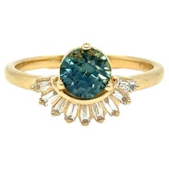 Anillo de compromiso de zafiro verde azulado y diamante baguette.