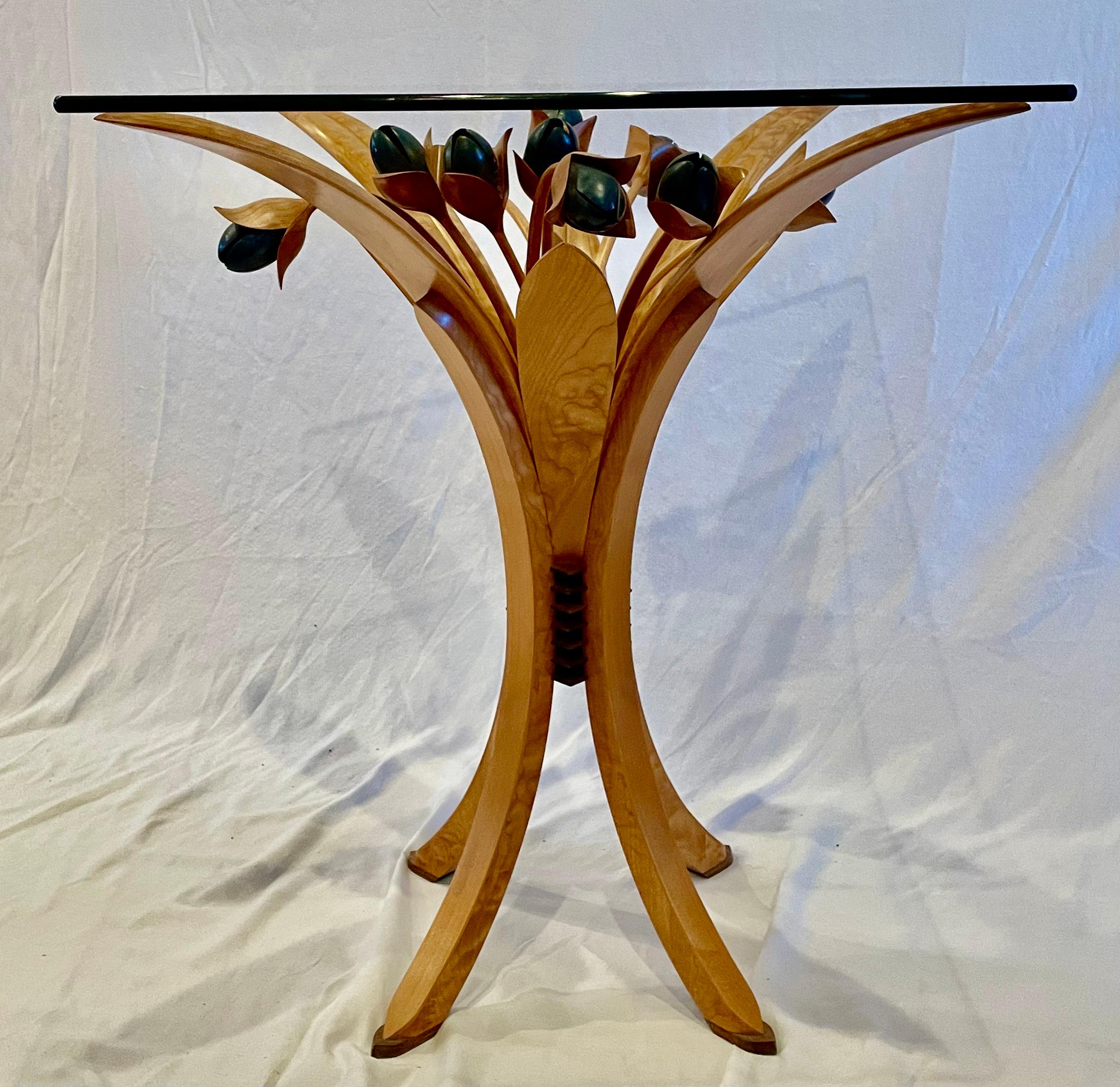 This unique bistro table is made with beautiful, quilted maple and deep teal tulips created with a translucent stain. There are wenge accents in the detailed base. The buyer adds their own 30