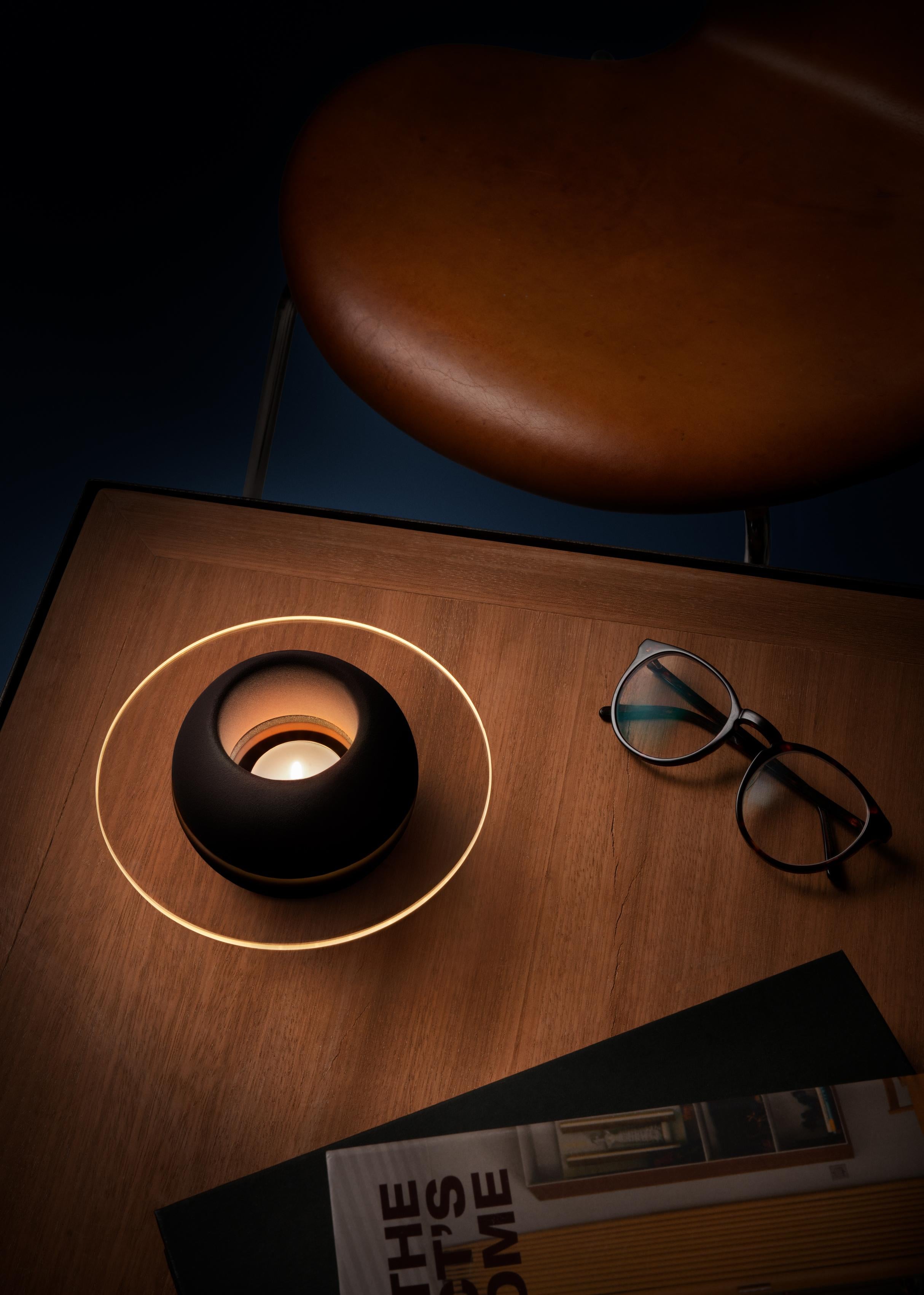 Sfär is a tealight holder composed of three parts. A two-part spherical shape in porcelain made in the porcelain factory in Lidköping, Sweden. A sheet of glass in between that is water-cut in Emmaboda, Sweden. The glass has a cut out hole on the