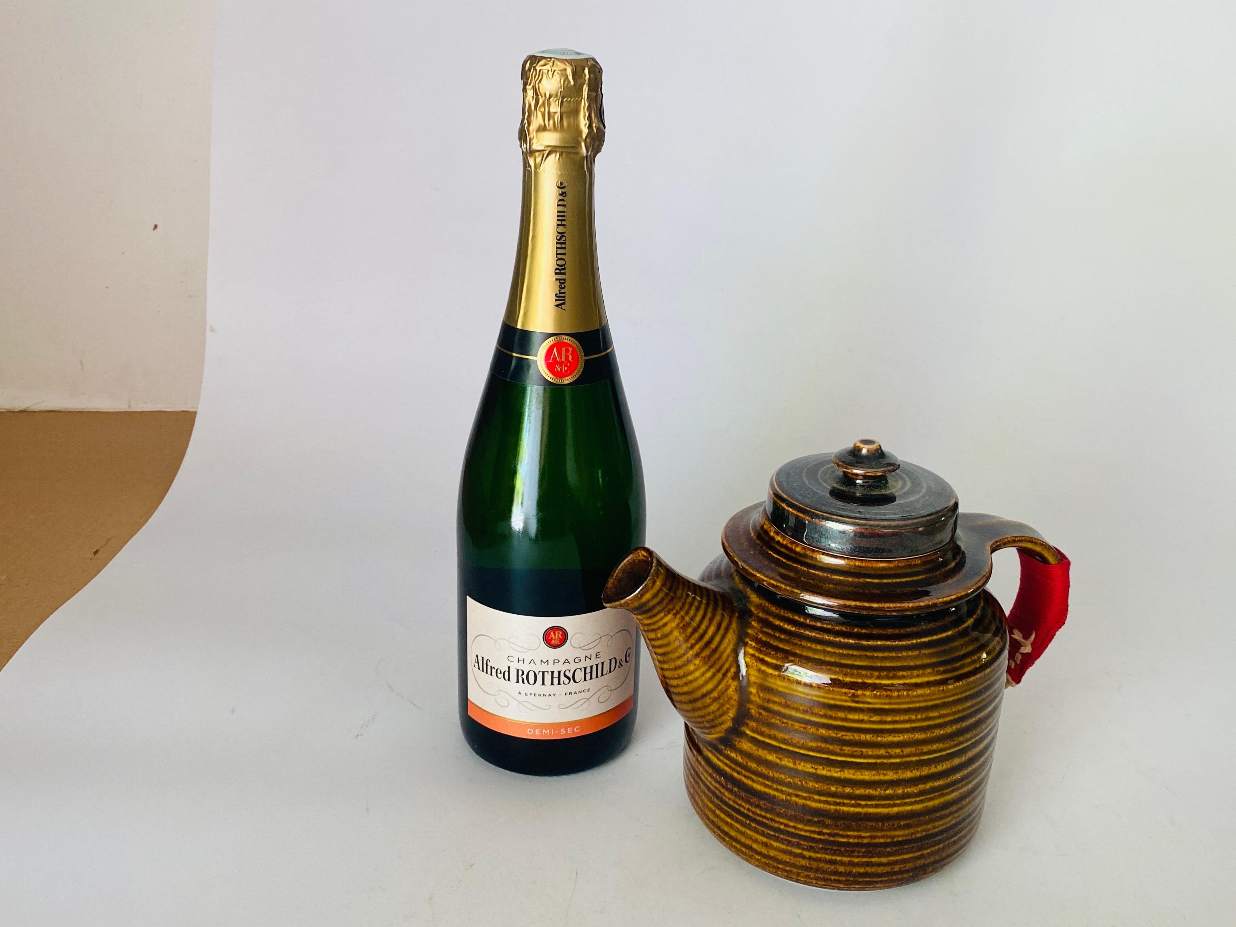 Teekanne Arabien Finnland
 Teekanne, entworfen CIRCA 1950, hergestellt CIRCA 1950.
Gebranntes und glasiertes Steingut, braun lackiert, Keramikgriff mit umlaufendem Stoff.