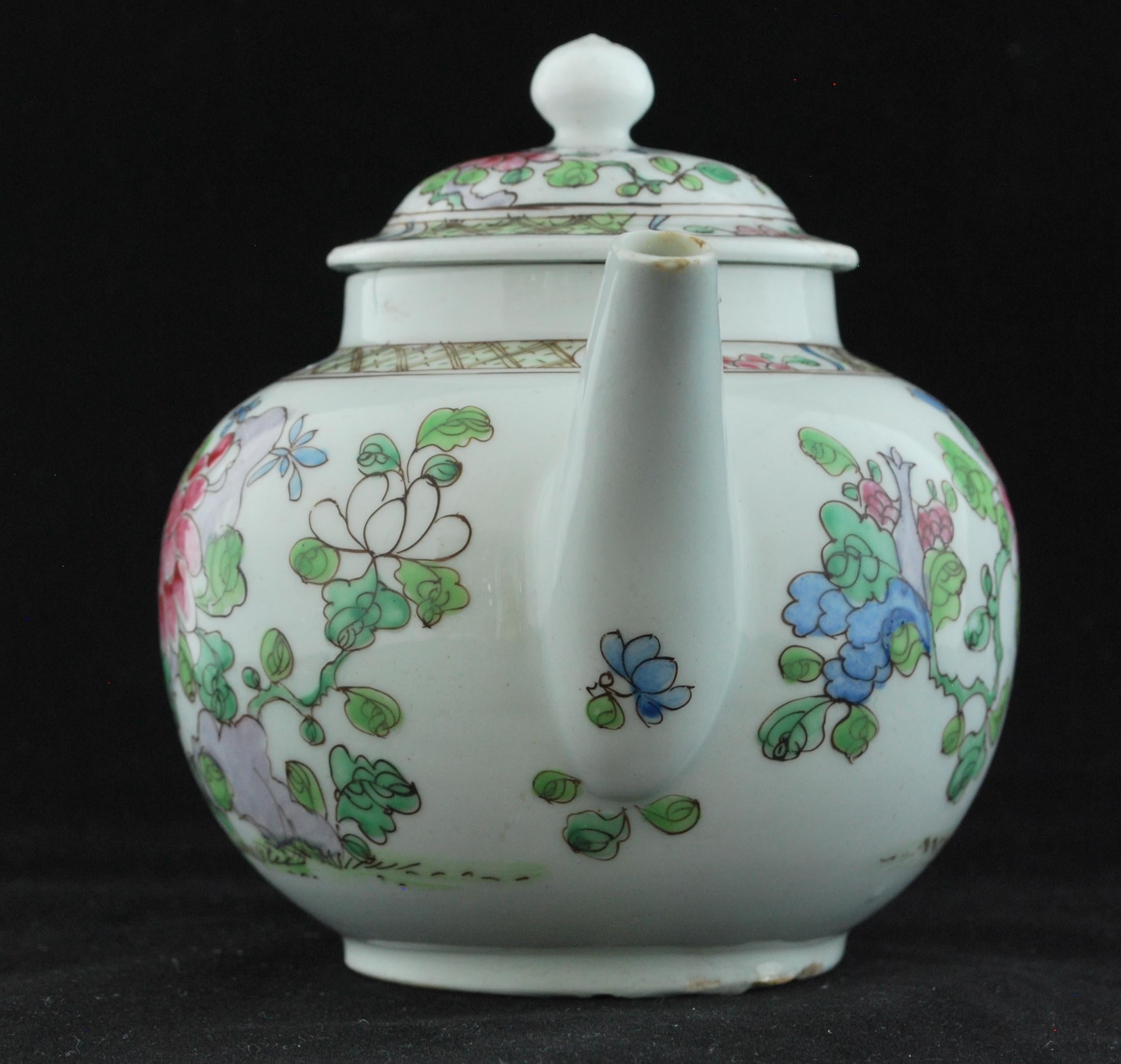 Small pot with loop handle, curved spout and domed cover with ball finial, the body painted after the Famille rose with chrysanthemum, flowers and leaves, all from mauve rocks on green, brown-lined grass, and beneath a diaper border, the cover