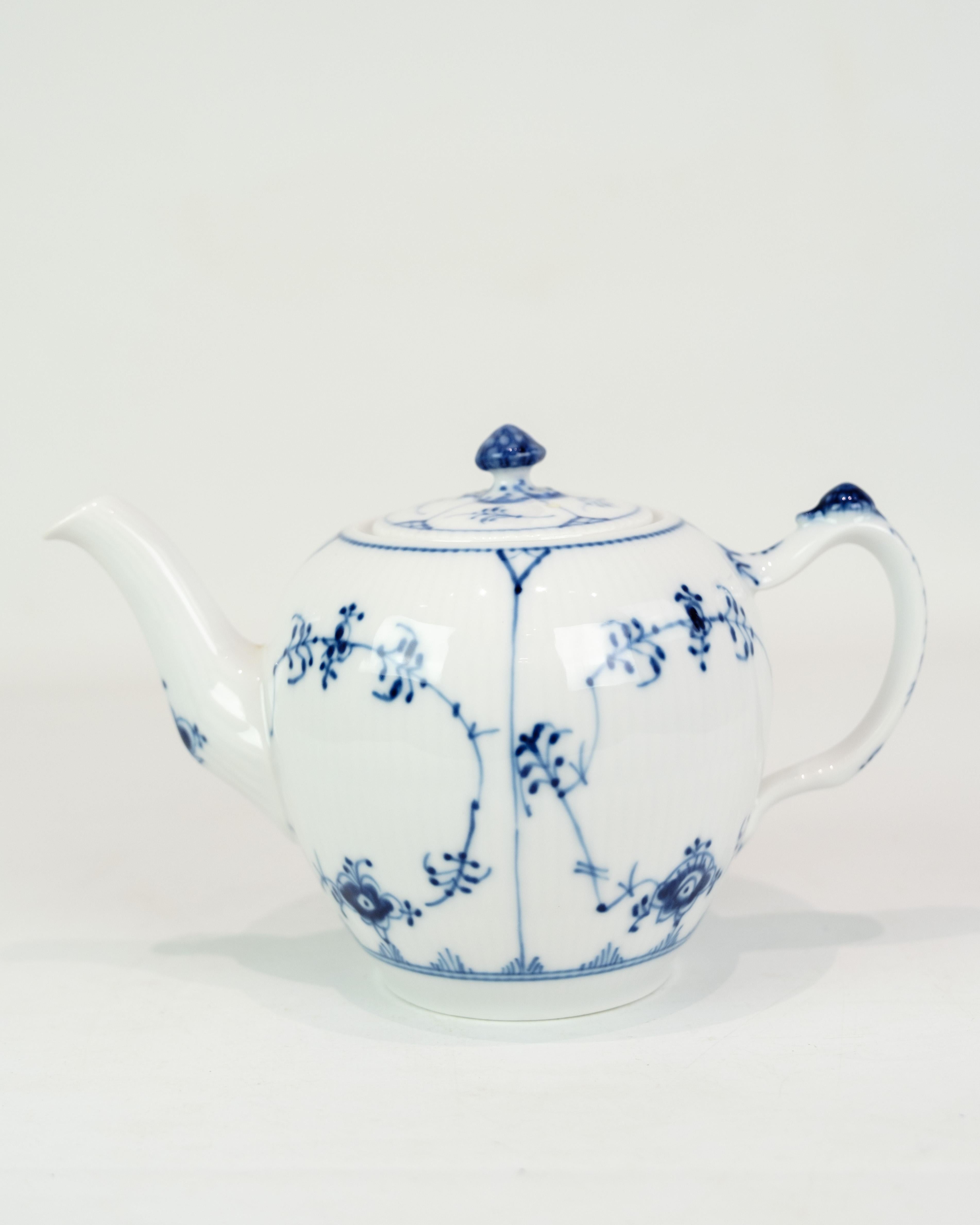 Tetera en Kgl. Mejillón acanalado de Royal Copenhagen, compuesto por la tapa n.º (1/257) y la olla n.º (1/258), fabricado en la década de 1930. Esta tetera clásica es un bello ejemplo de la artesanía y la tradición de diseño atemporal de Royal