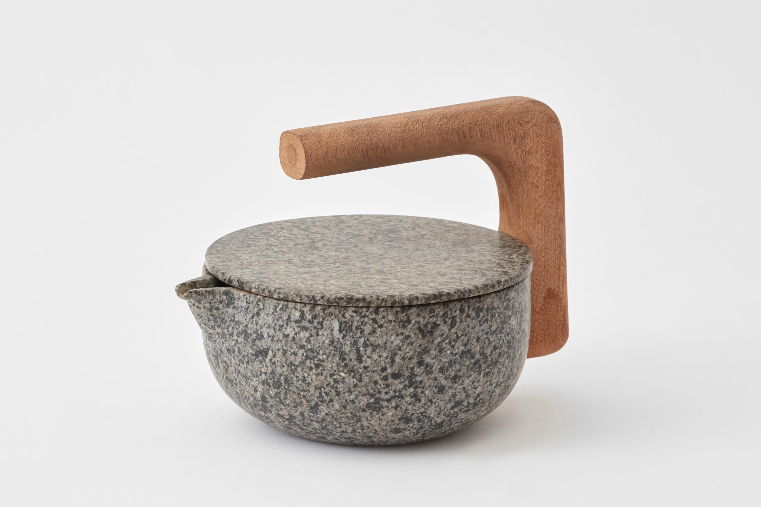 Teapot N°2 by Estudio Rafael Freyre
Dimensions: W 27 x D 15 x H 15.5 cm 
Materials: Andes Granite, Amazonic Wood.

Tea pot is an everyday object that explores the ritual relationship of water and plant use. Hot water, in contact with plant