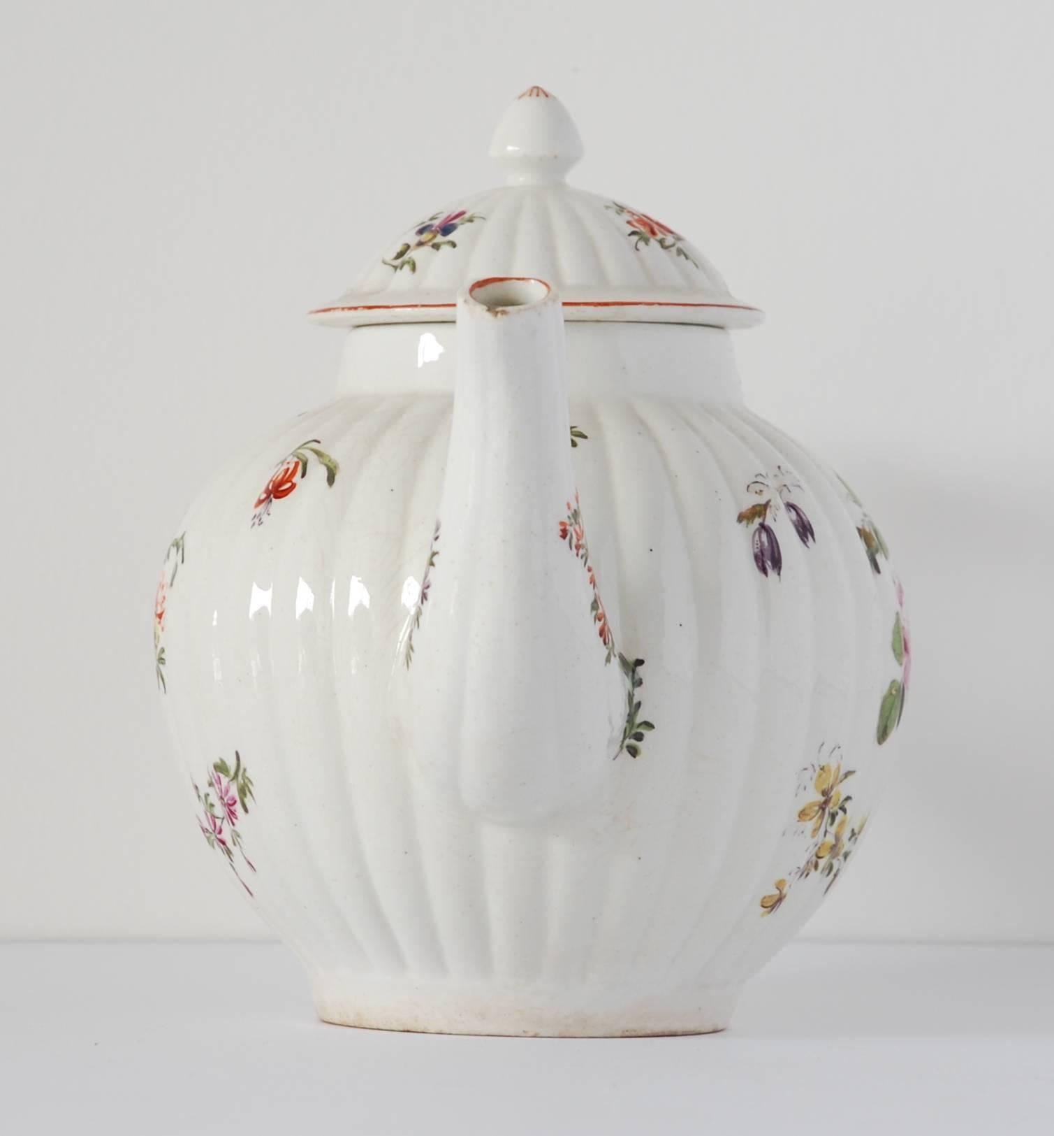 A gadrooned, canon-ball shape teapot, decorated with typical sprays of natural flowers.


 