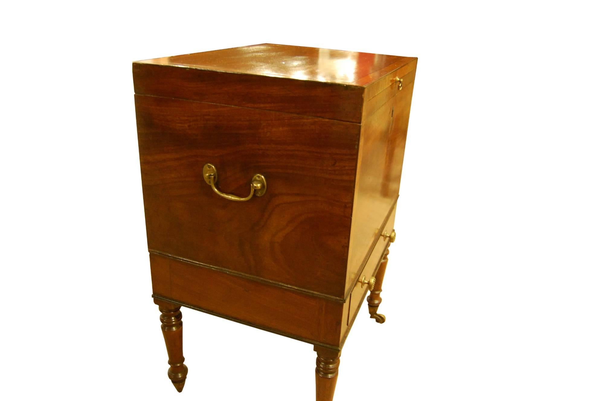 Regency mahogany teapoy or decanter box on a stand crossbanded in tulipwood,

The interior has single remaining tinned caddy, tinned hot tray, and a single drawer below,

circa 1810.
 
