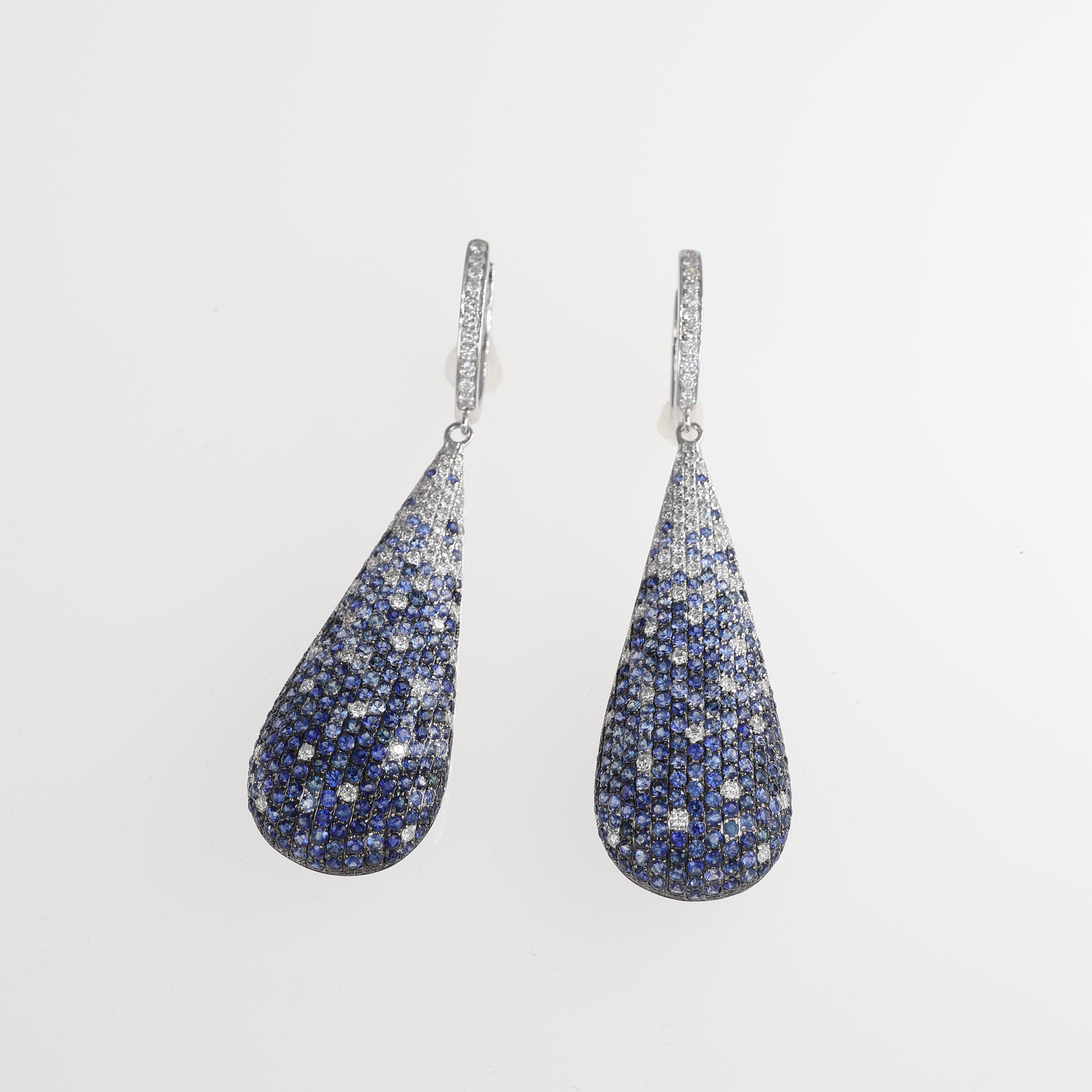 Elegant teardrop-shaped drop earrings crafted in 18kt white gold, featuring a stunning pavé of natural blue sapphires. The gradient effect transitions from deep blue to brilliant-cut natural diamonds, creating a captivating play of light. A refined