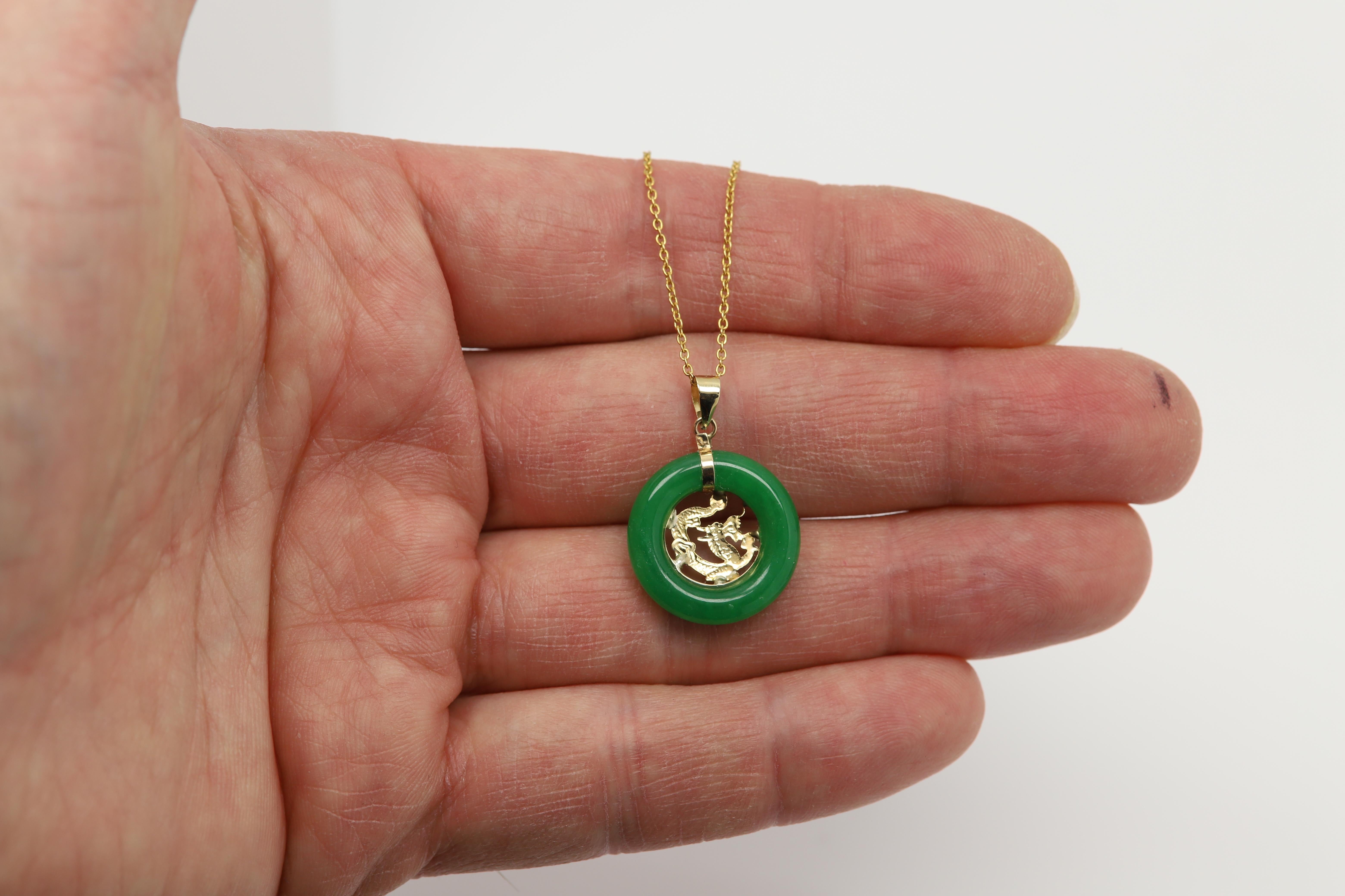 Beautiful Jade Round Circle Pendant
14k Yellow Gold 
Natural jade with color treated (standard and common).
overall weight 2.2 grams (without a chain).
Size: Stone size is approx  18 mm in Diameter.
Inside is a gold Dragon Design
Included basic